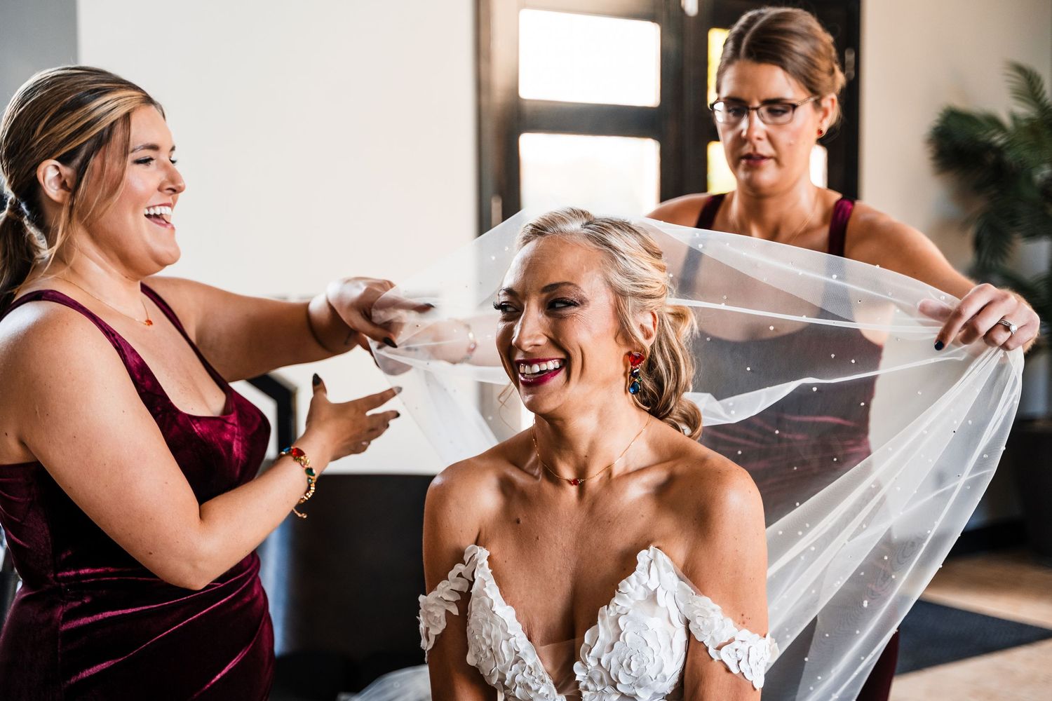 A series of joyful moments as the bride's veil is being placed during wedding preparations.