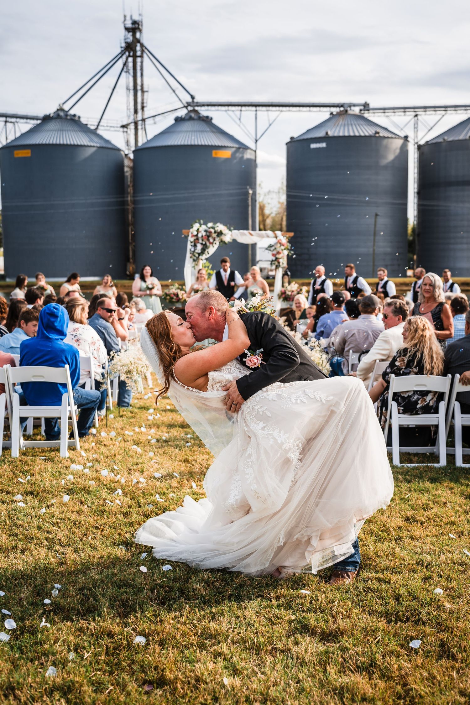Wedding couple sharing a romantic dip pose with grain silos in the background.