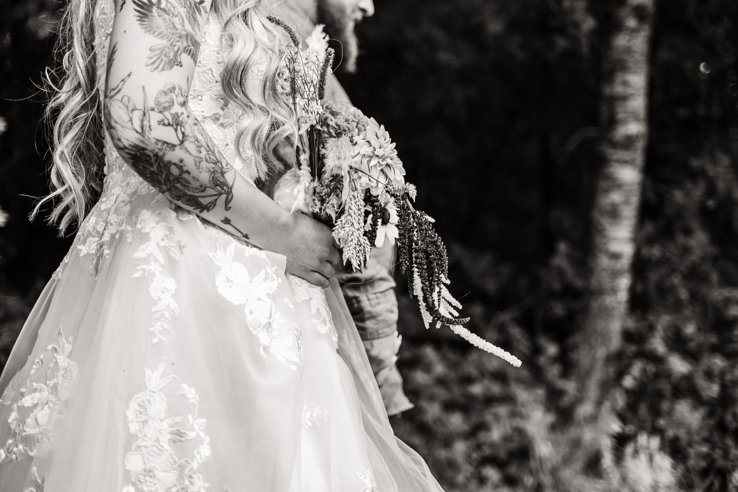 Artistic black and white close-up of a bridal gown with lace details.