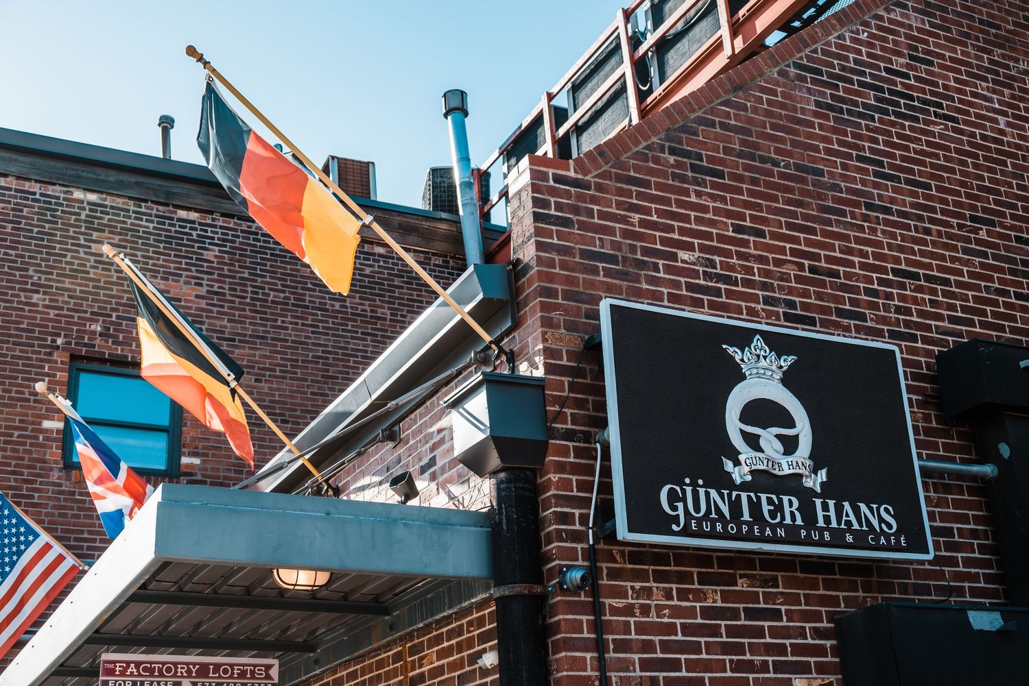 Exterior view of Gunter Hans building with international flags displayed on brick facade.