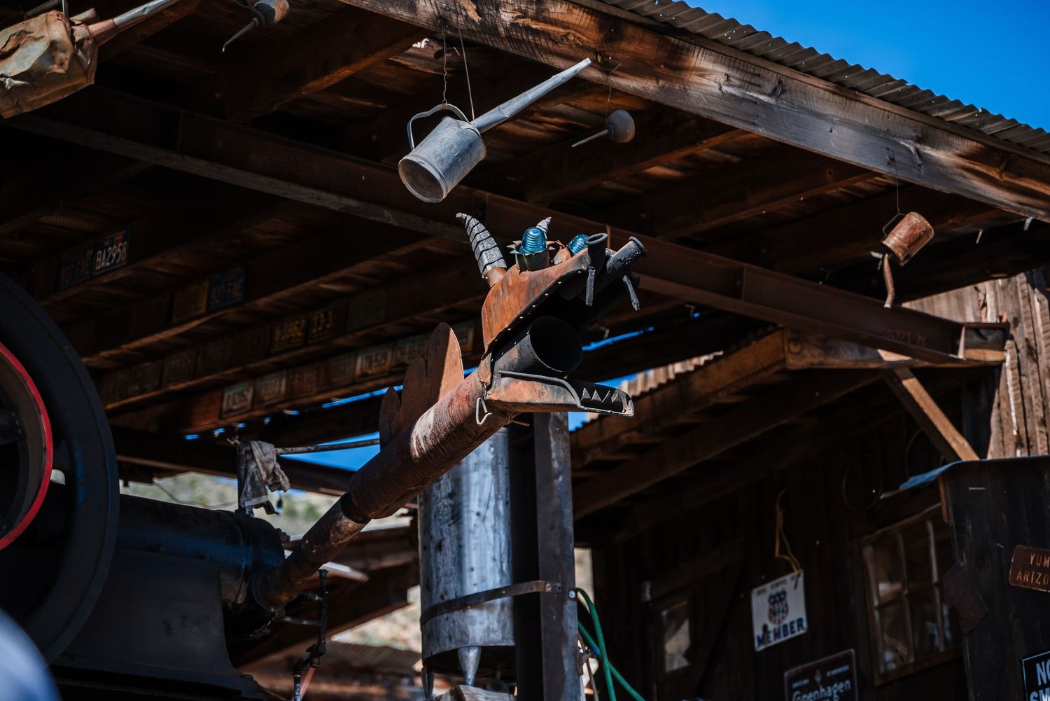 Various pieces of equipment suspended from rustic wooden rafters under a covered outdoor structure.