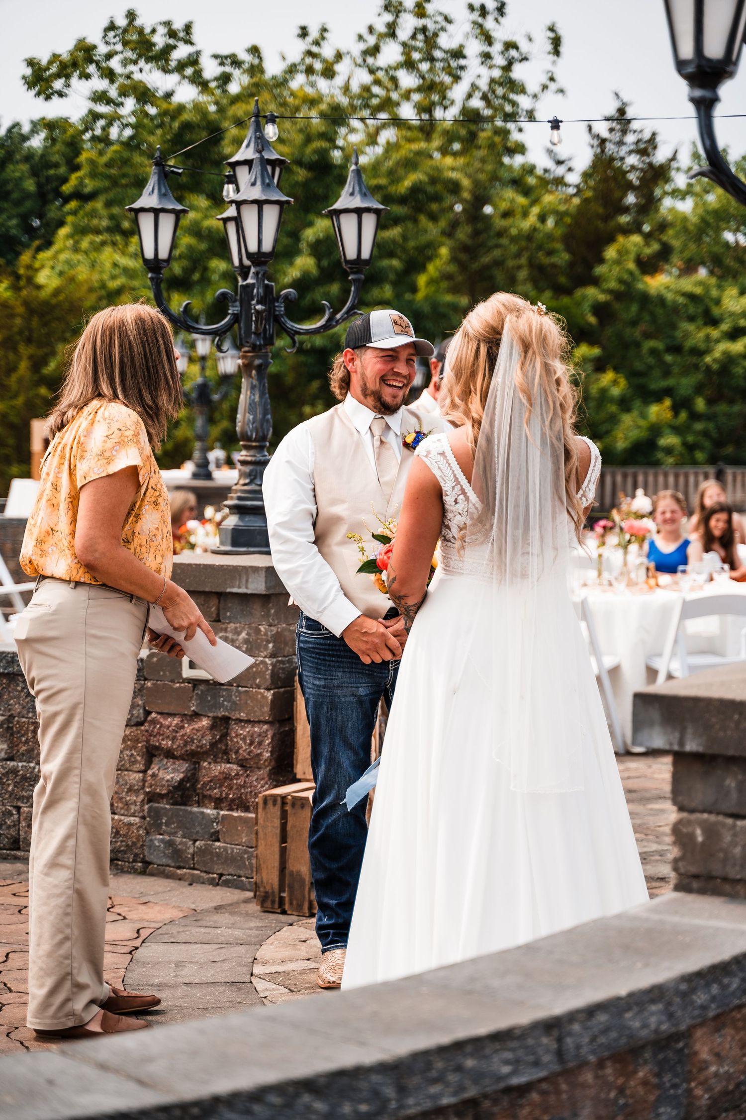 Wedding ceremony moments captured on a stone terrace with decorative lanterns.