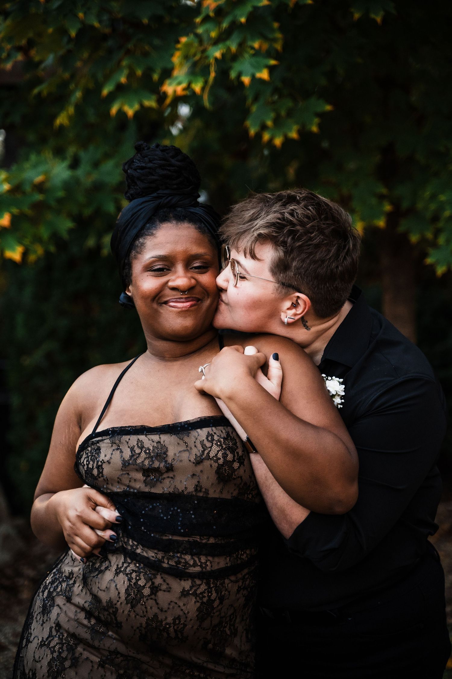 Joyful outdoor wedding portrait with couple sharing affectionate moment among autumn leaves.