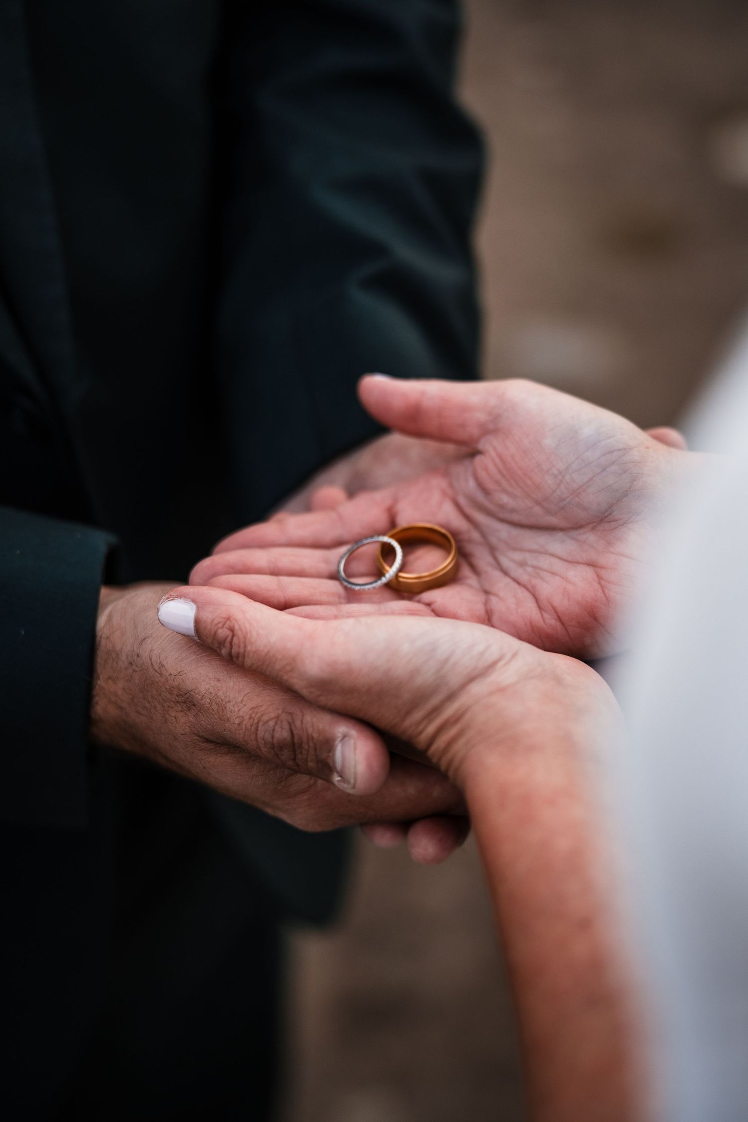 Close-up shots of wedding rings being exchanged between hands during a ceremony.