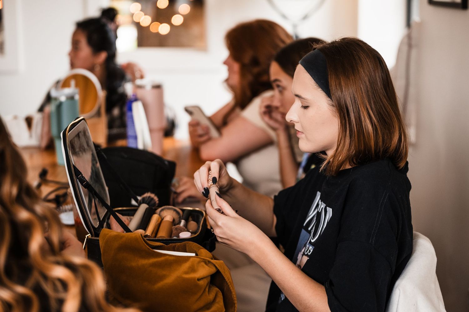 Wedding preparation scene with makeup and styling tools laid out on a table.