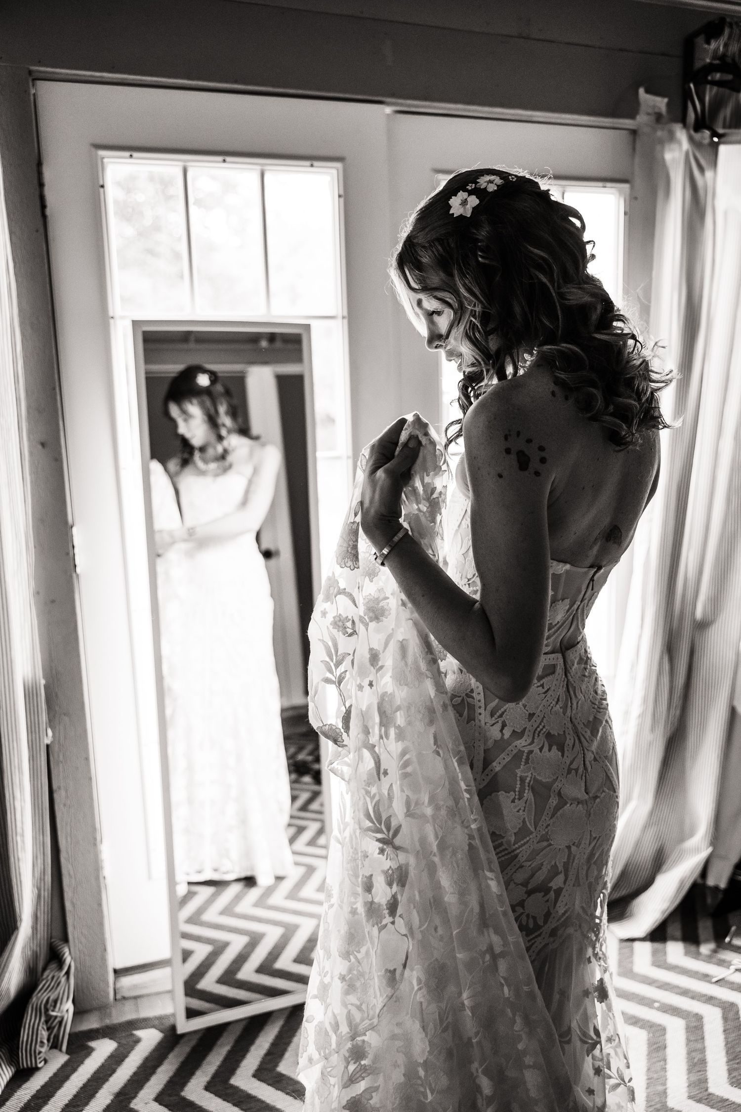 A series of black and white photos showing a bride in a lace wedding dress by sunlit windows.