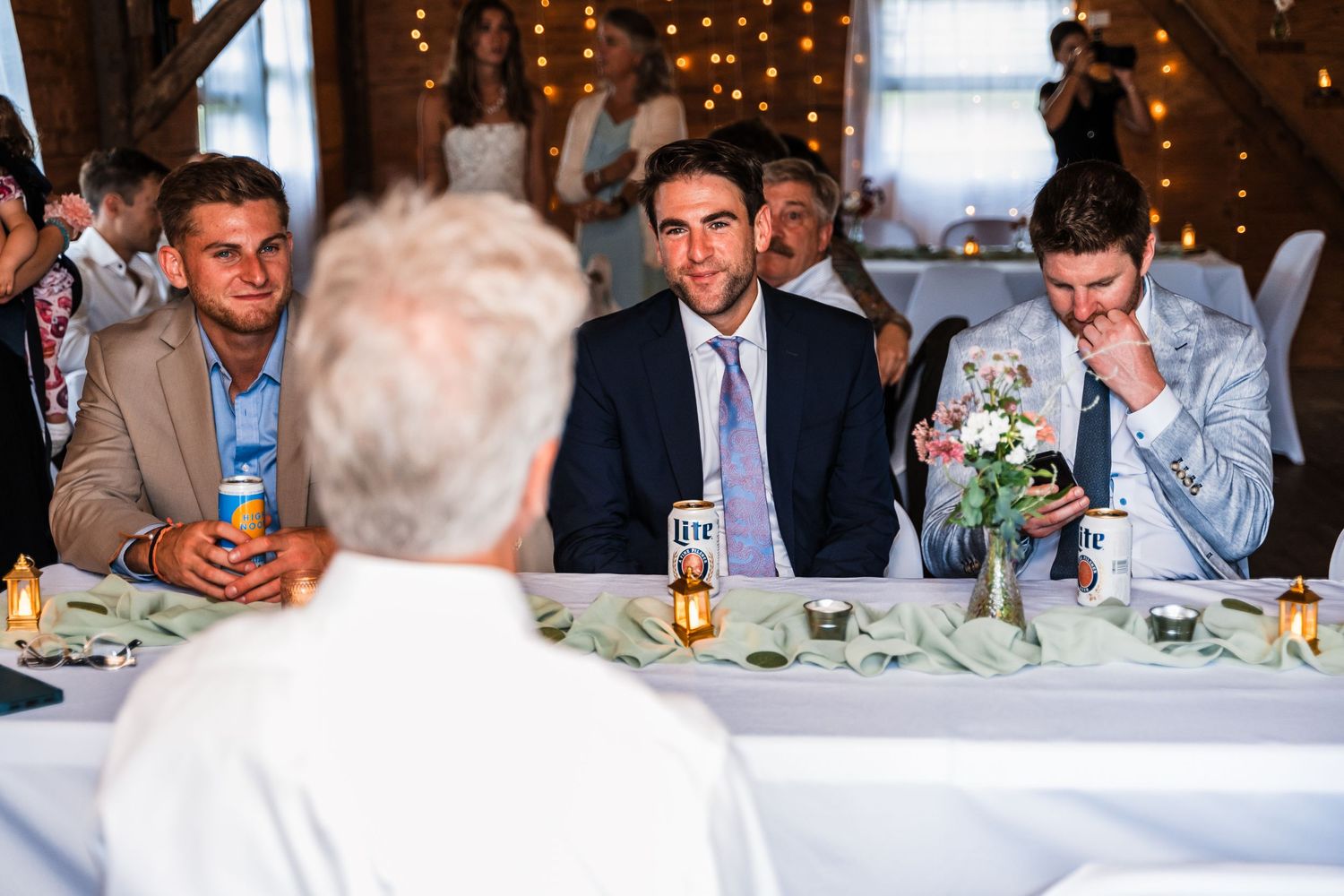 Wedding guests enjoying dinner and conversation at a decorated indoor reception table.