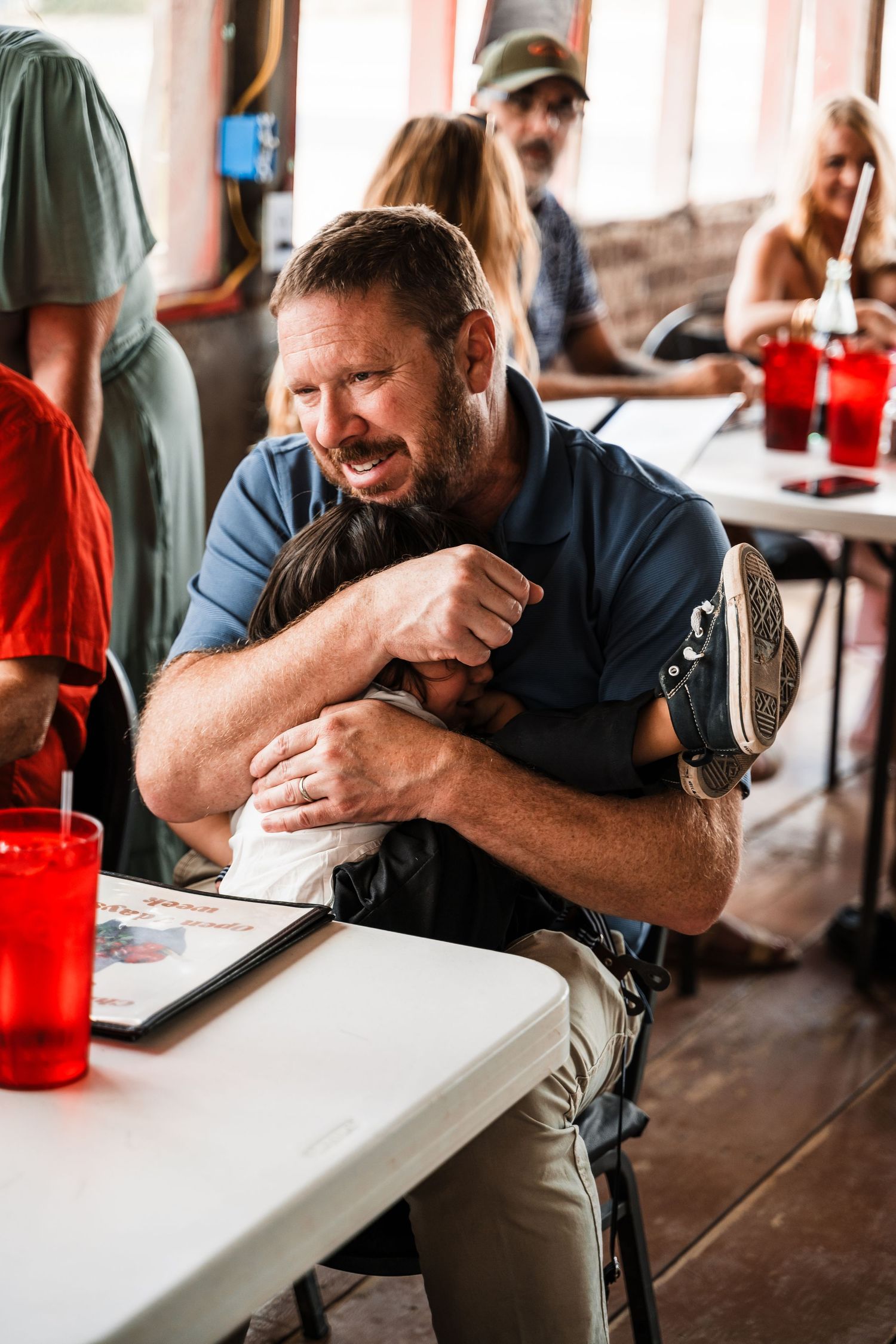 Diner patron enjoying a meal at a casual restaurant with red plastic cups on the table.