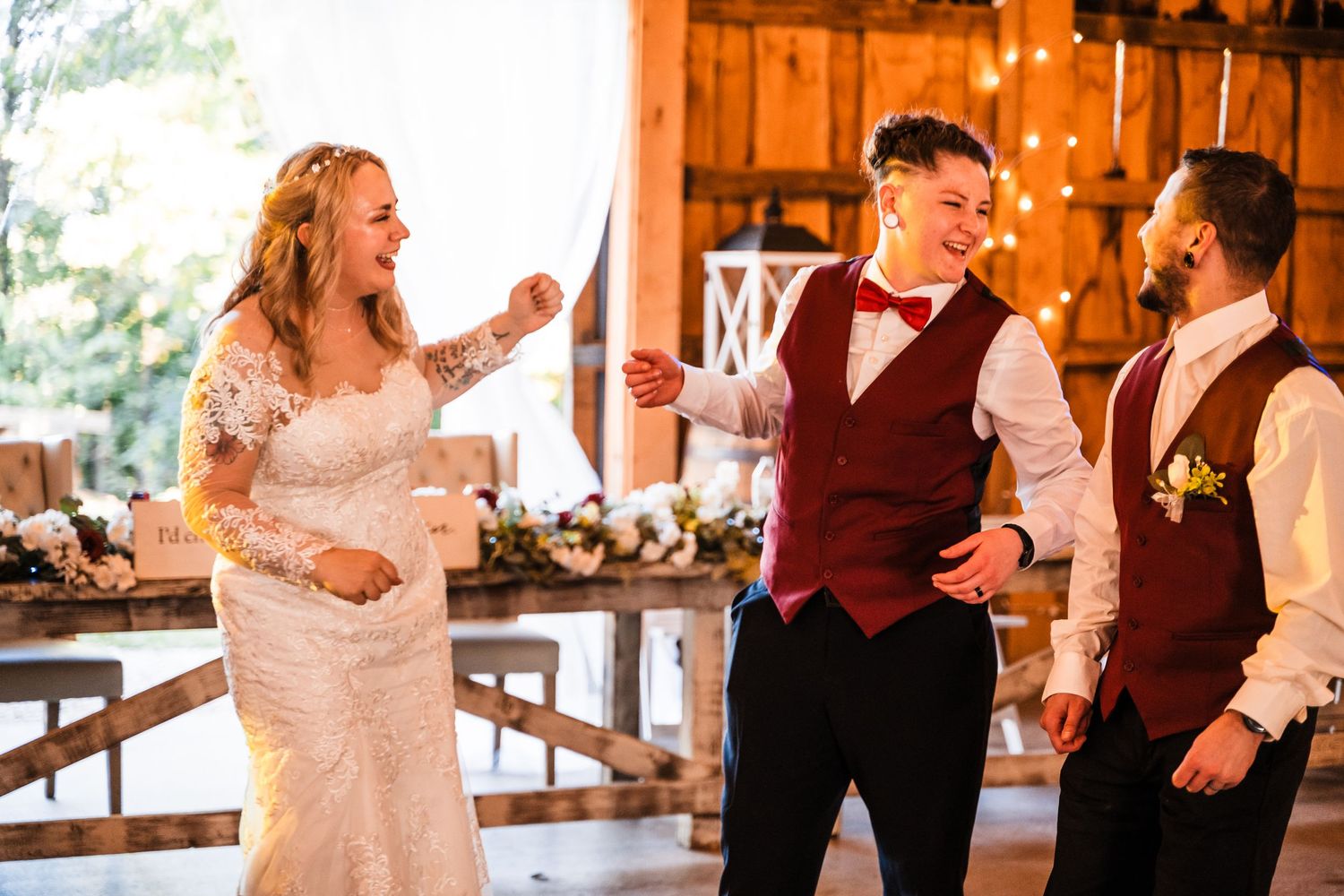 Wedding celebration inside a rustic barn venue with joyful dancing and laughter.