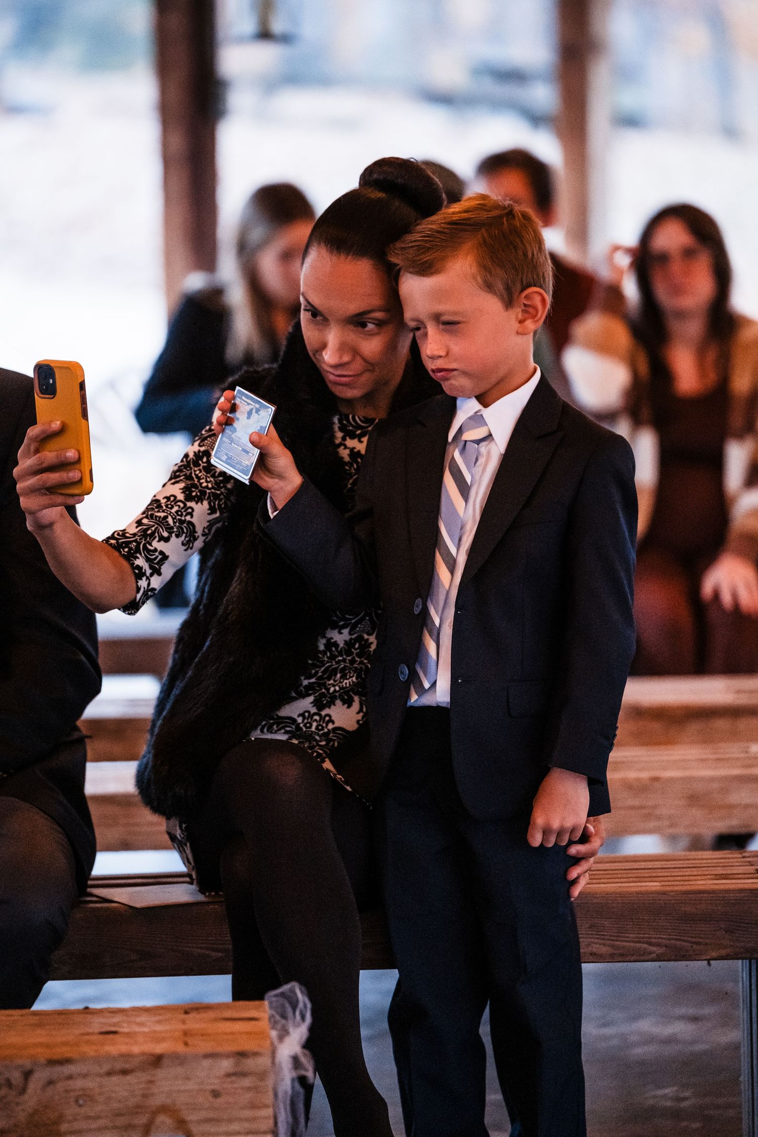 Wedding guests taking selfie photos at rustic barn venue.