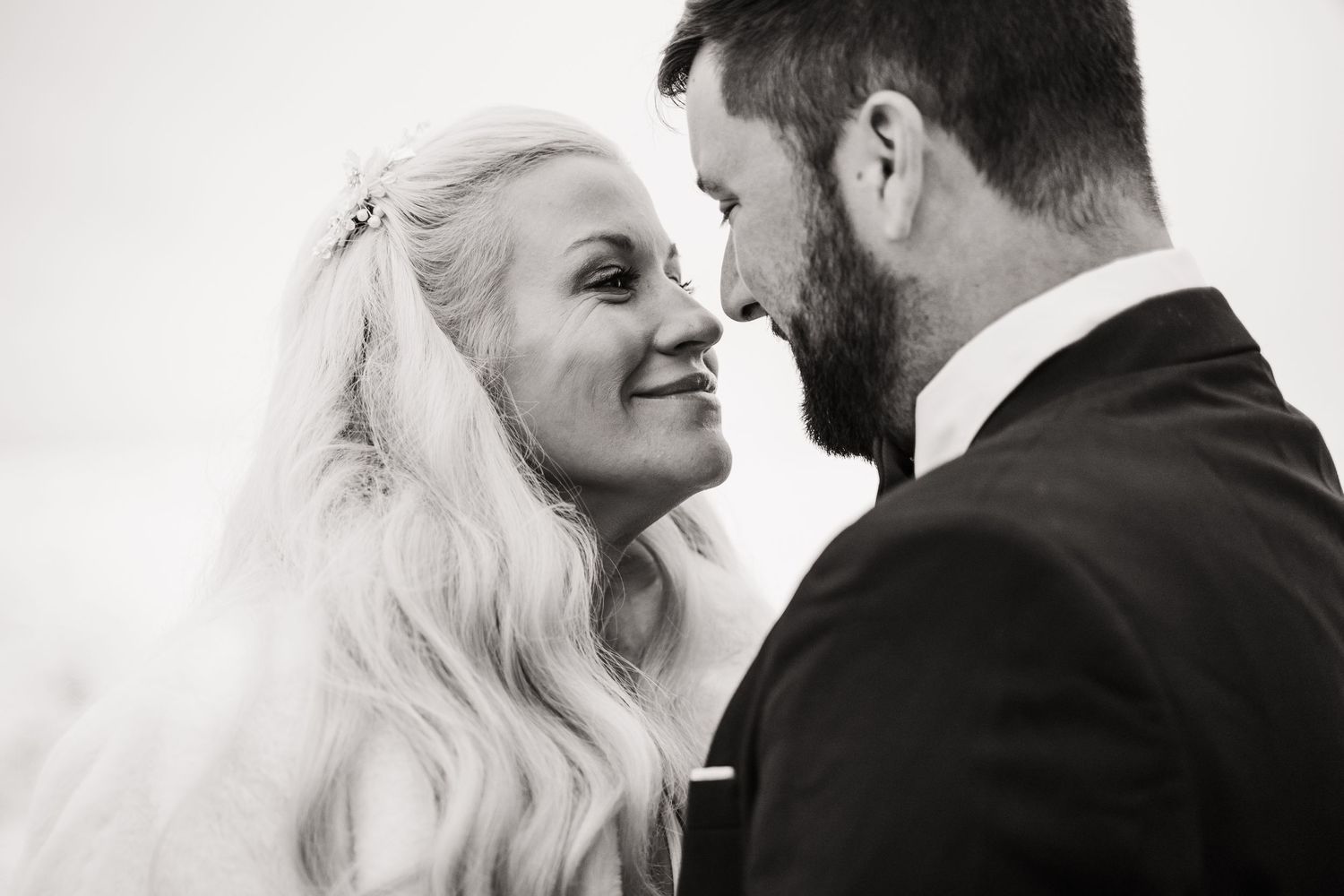 Black and white intimate portrait of wedding couple sharing tender moment.