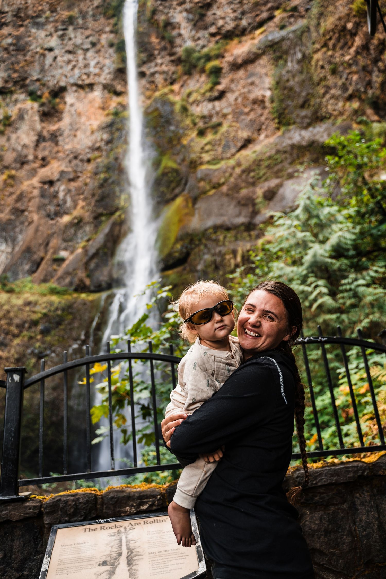 Joyful moment captured in front of Multnomah Falls waterfall in Oregon.