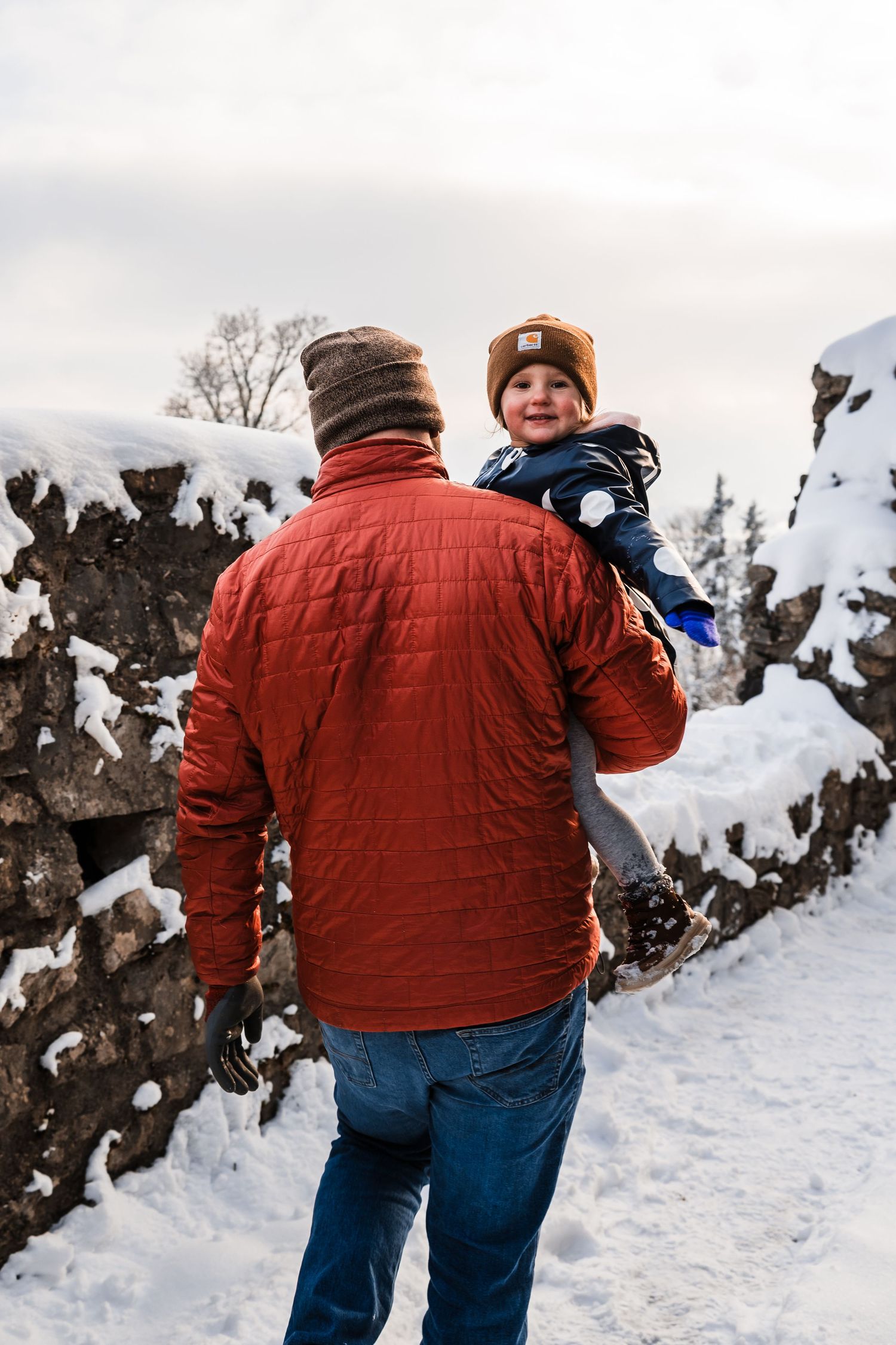 Winter scene with snow-covered rocks as two people share a moment outdoors.
