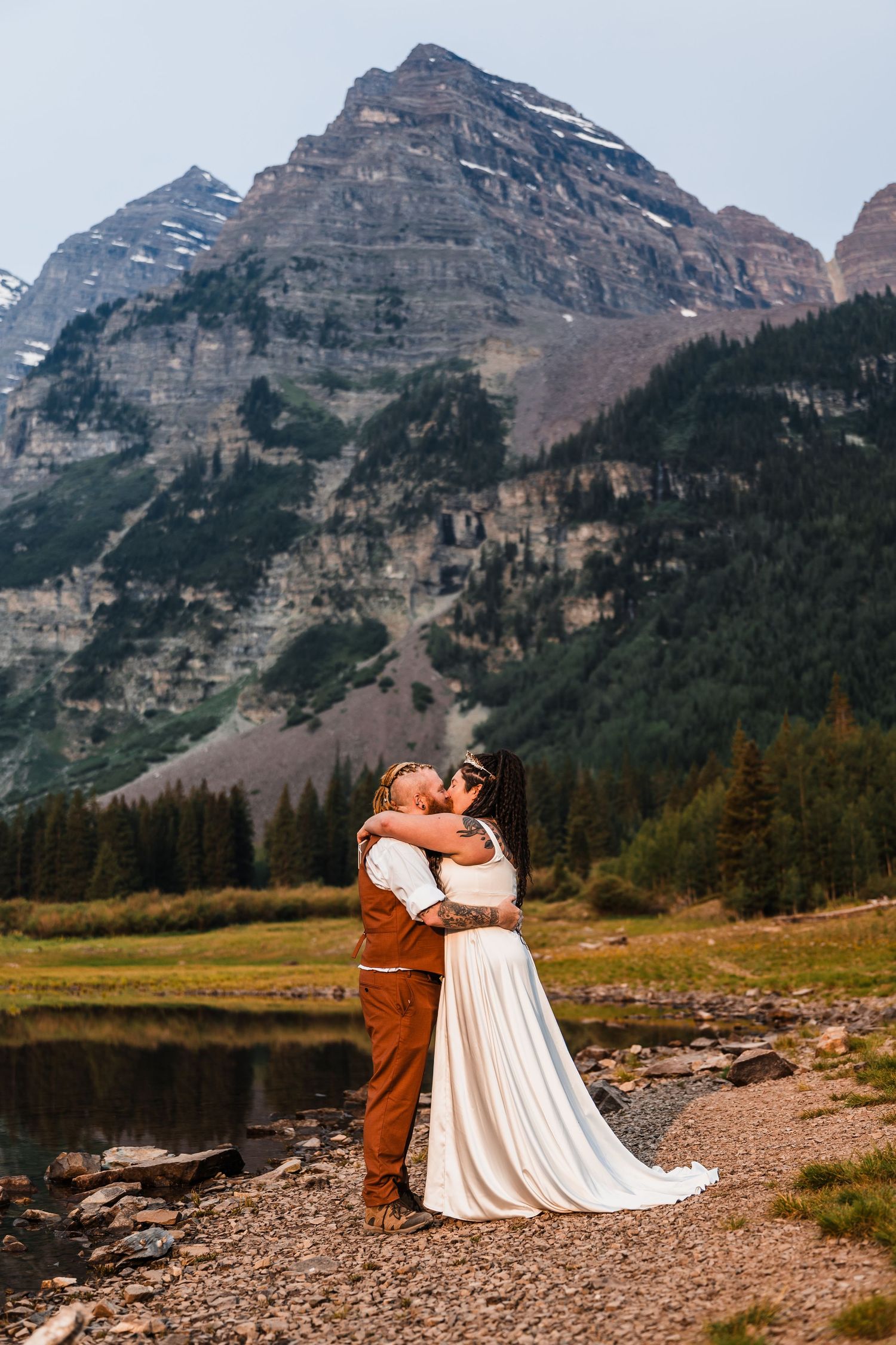 Couple sharing first kiss at Maroon Bells Colorado elopement with stunning rocky mountain backdrop.