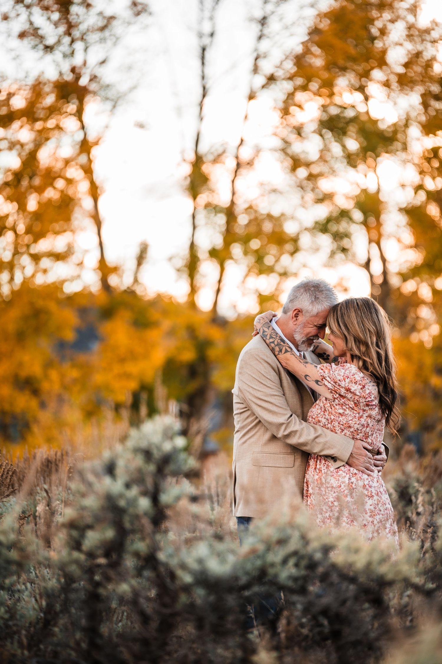 A romantic autumn photo series capturing tender moments between a couple against golden foliage and sage brush.