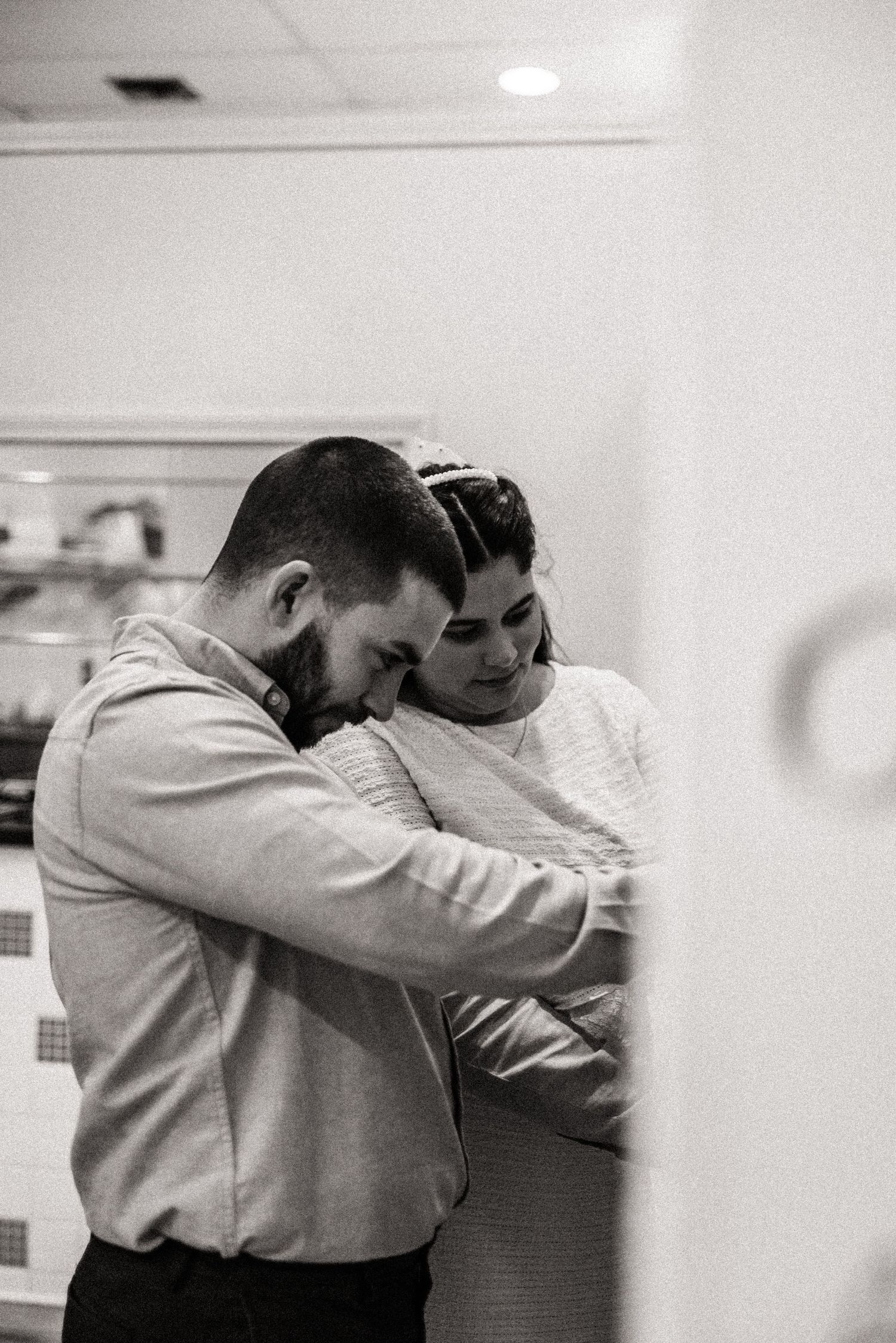 An intimate black and white moment between two people in an indoor setting.
