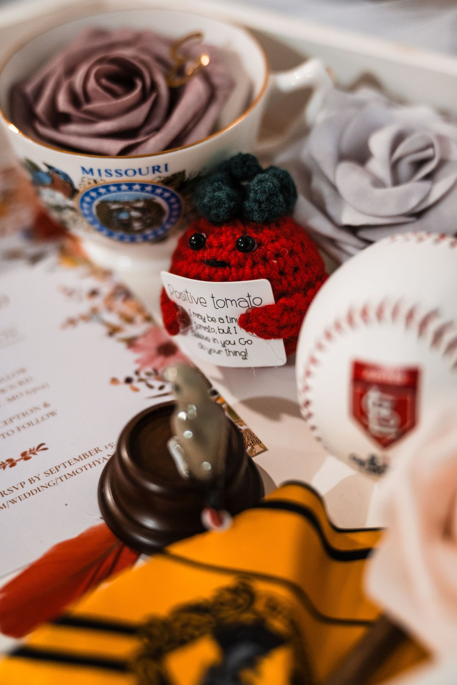 Close-up details of wedding decorations including chocolate roses and handwritten name cards on an orange surface.
