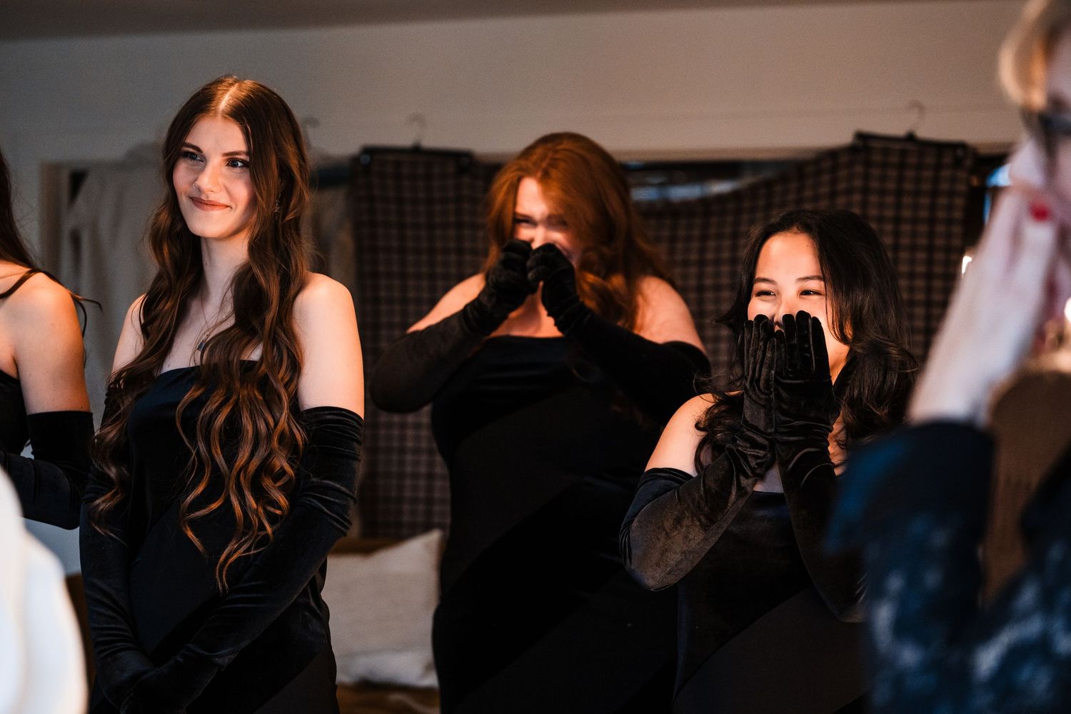 Wedding party members in black attire show emotional reactions during celebrations.
