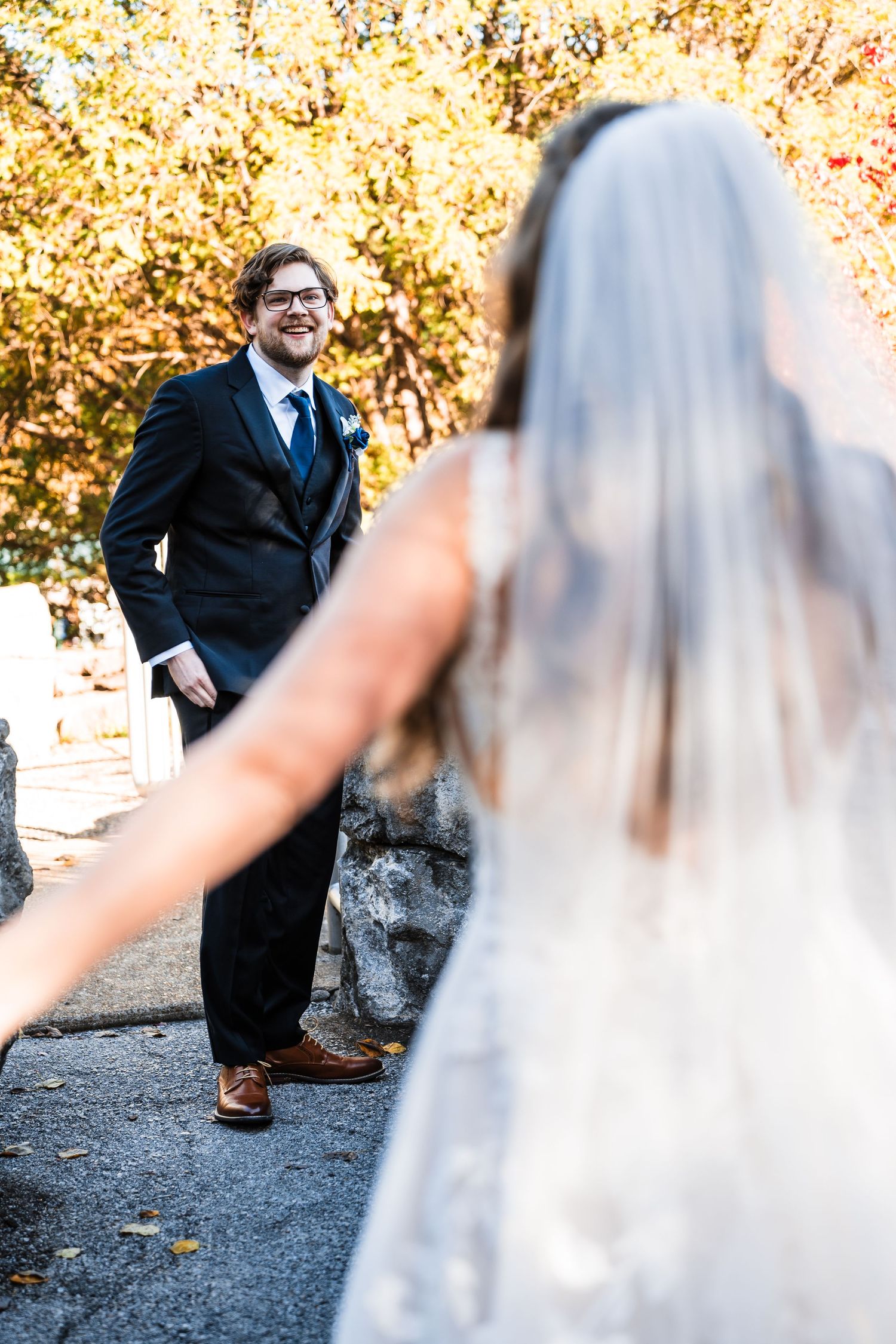 First look wedding moment captured in autumn with golden foliage in background.