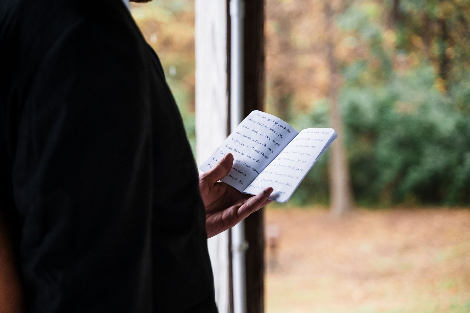 Silhouetted figures reading from books during outdoor ceremony or event.