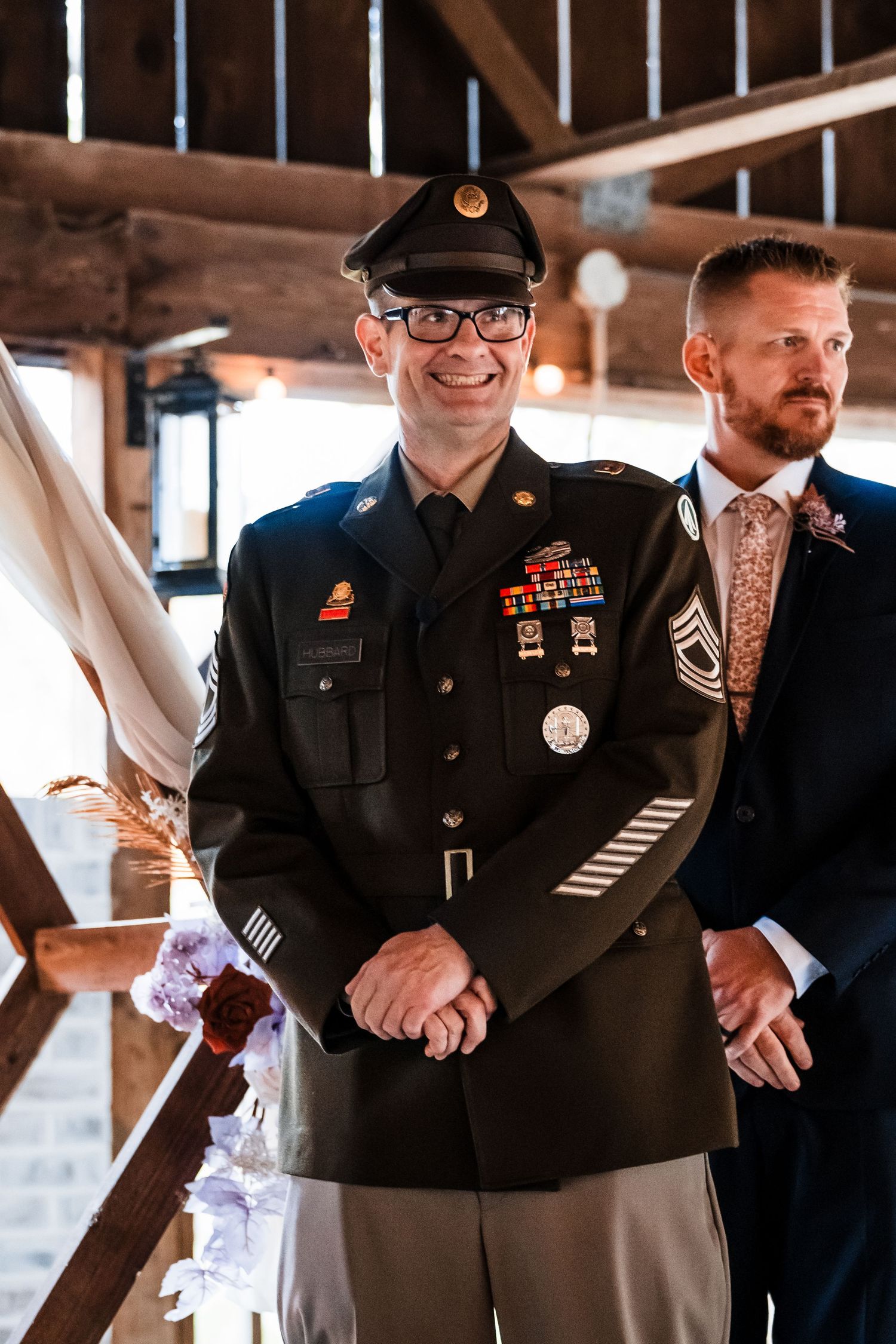 Military service members in dress uniforms stand together during a formal ceremony.