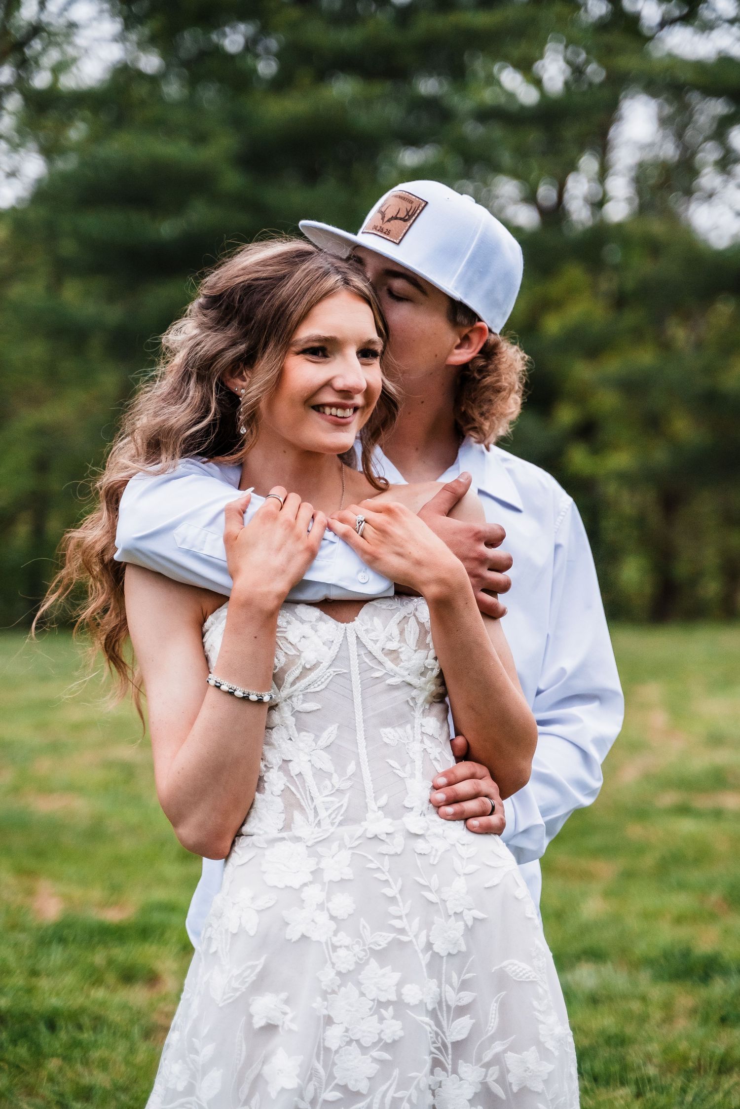 A romantic moment captured between newlyweds in a lush green outdoor setting.