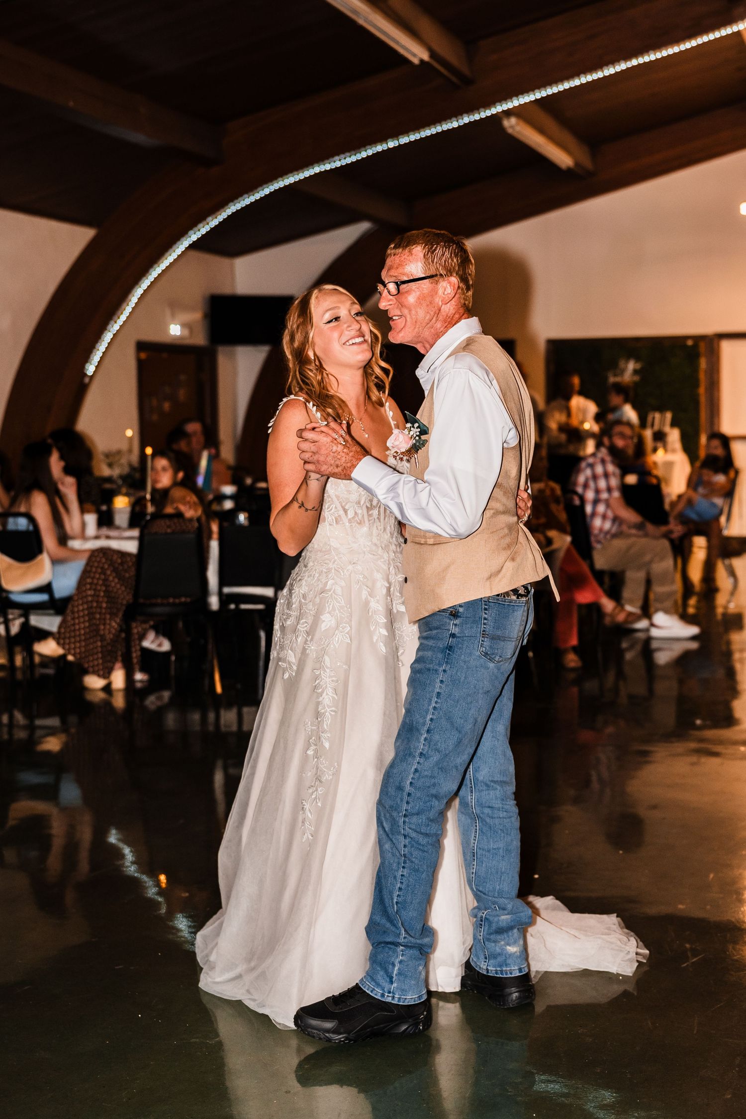 A sequence of warm-toned photos capturing an emotional dance between a bride in white and her dance partner at a reception.