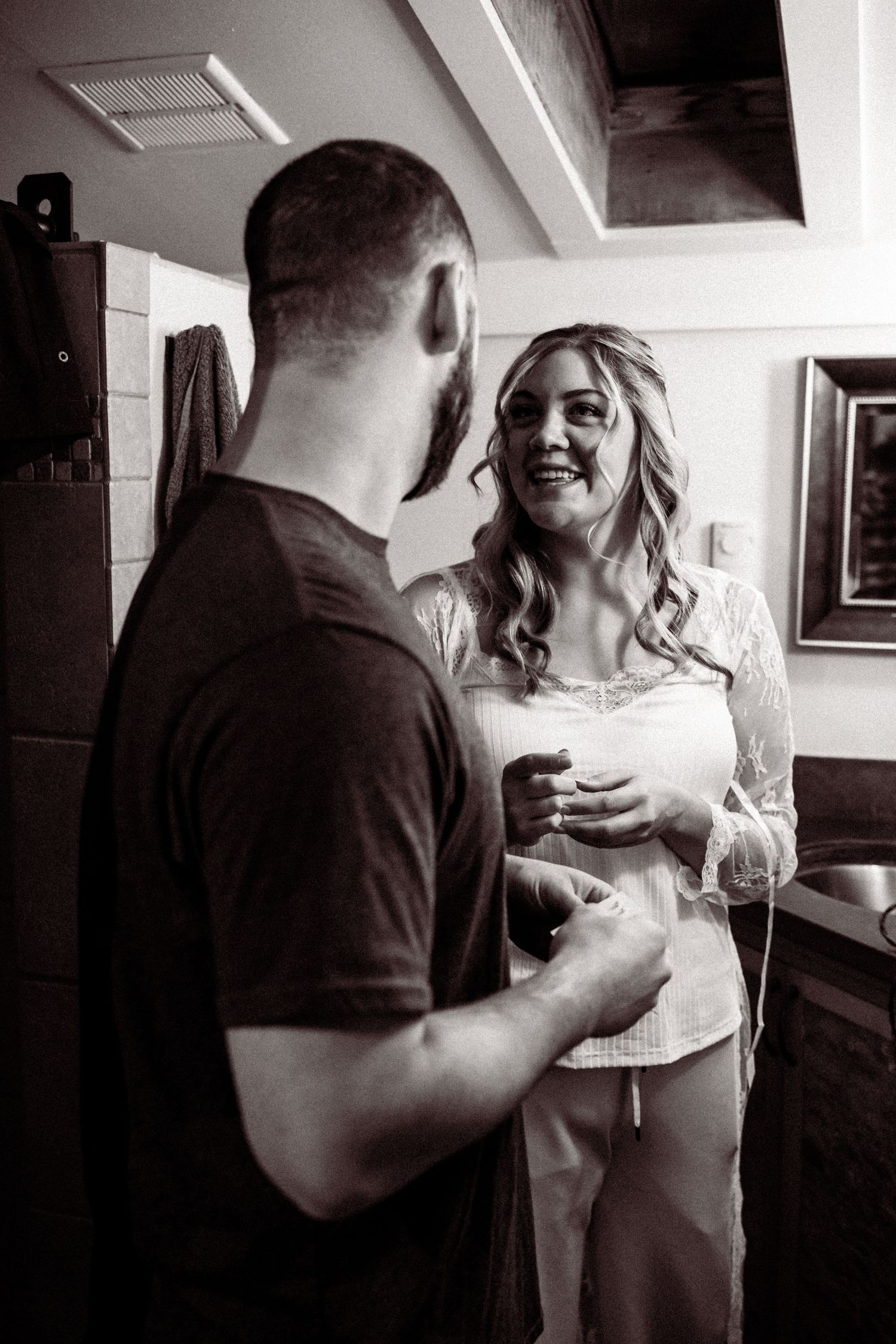 A series of black and white candid moments showing a couple sharing intimate conversations indoors.