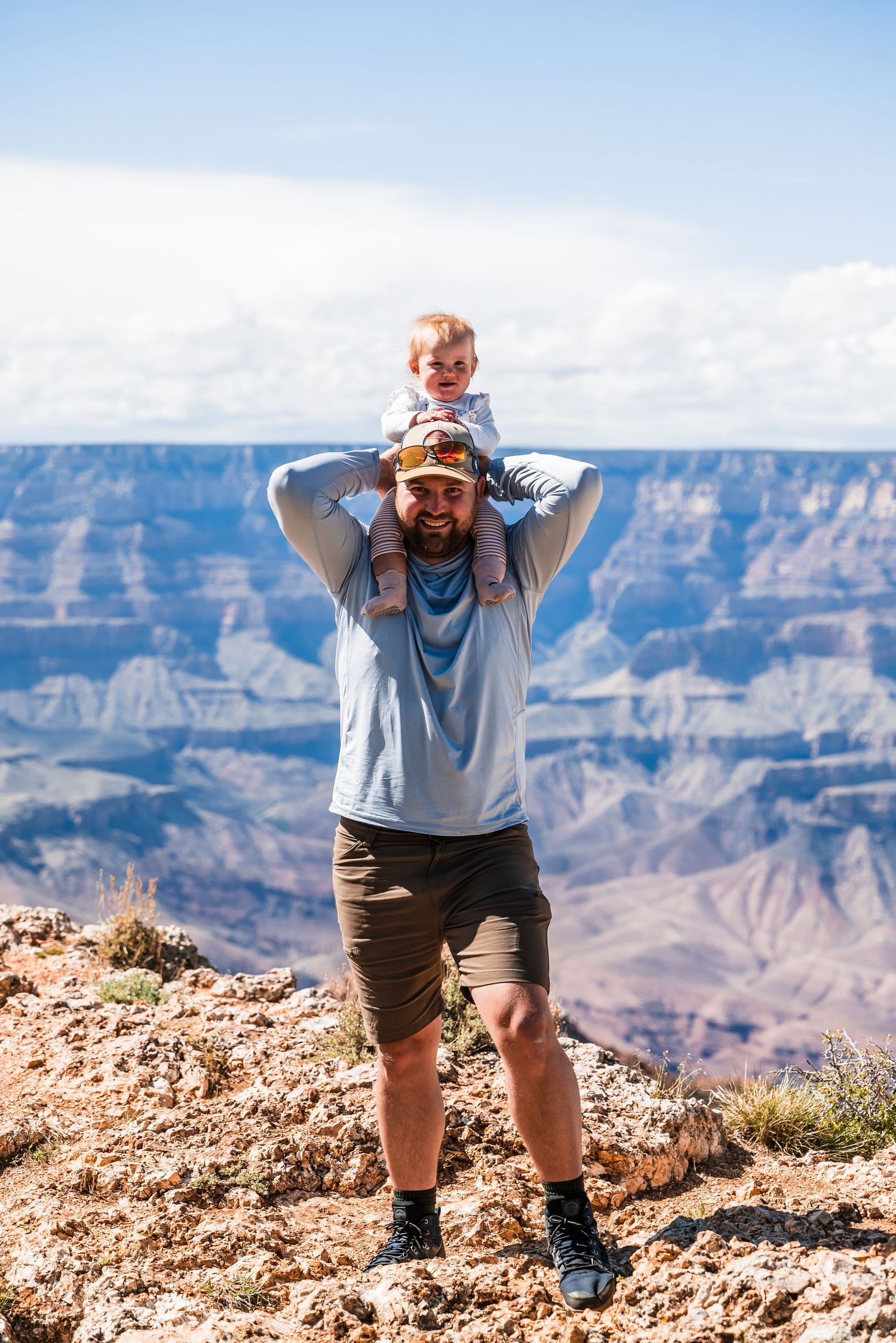 Scenic view of two people enjoying the majestic Grand Canyon overlook on a sunny day.