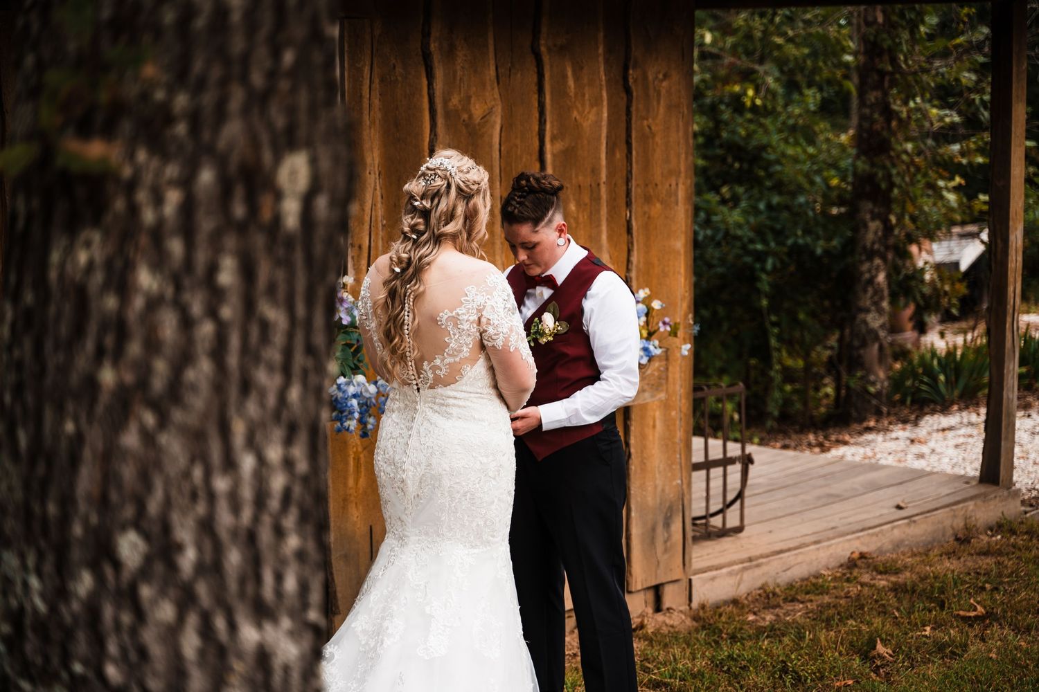 A bride and groom share an intimate moment against a rustic wooden backdrop.