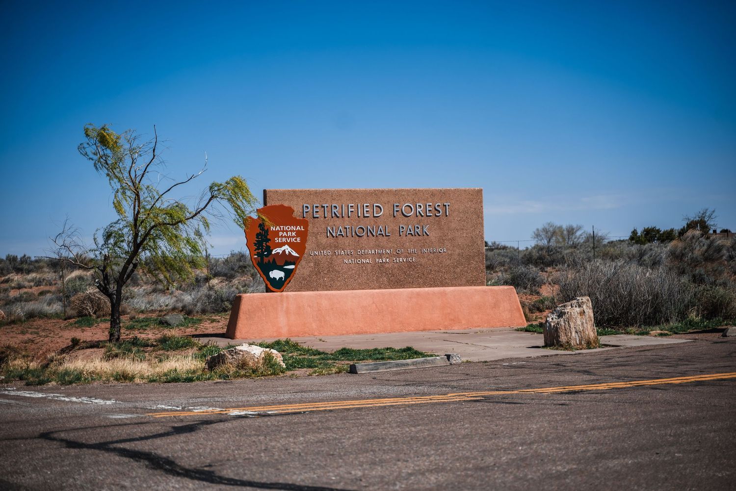 The entrance sign to Wupatki National Monument stands against a blue desert sky in Arizona.