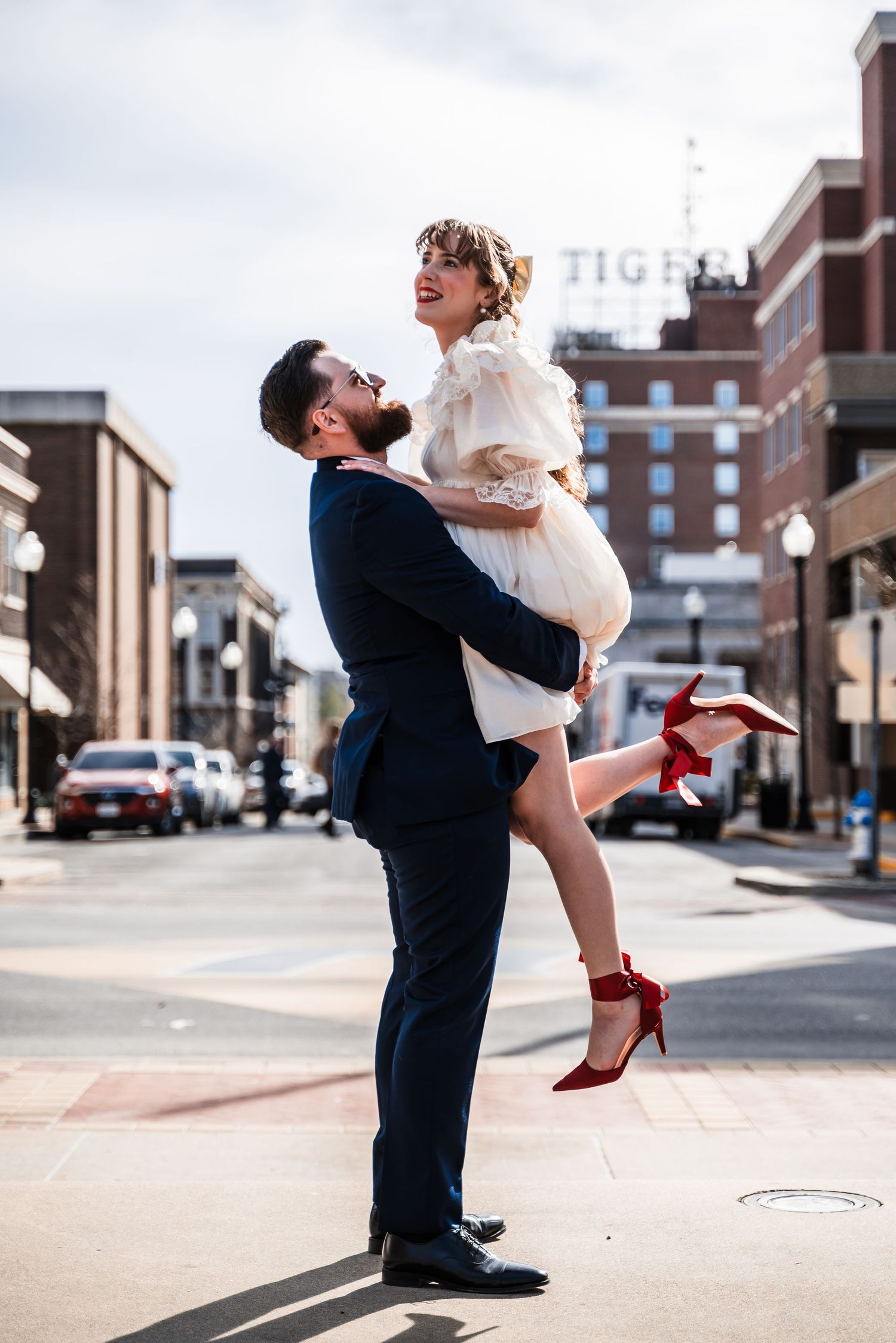 A joyful lift pose on a city street with urban buildings in the background.