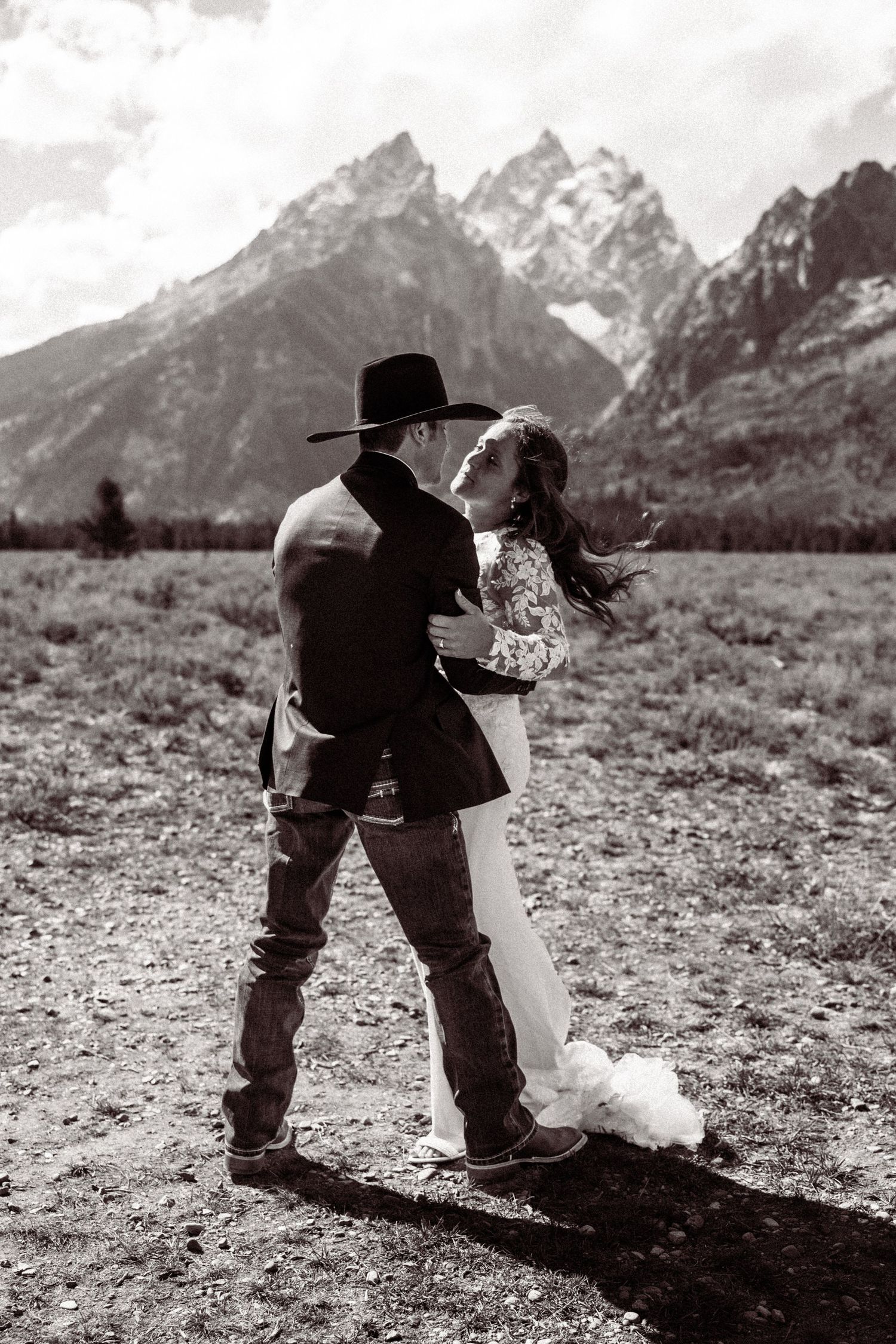 A sequence of black and white photos showing a couple dancing playfully against a mountain backdrop.