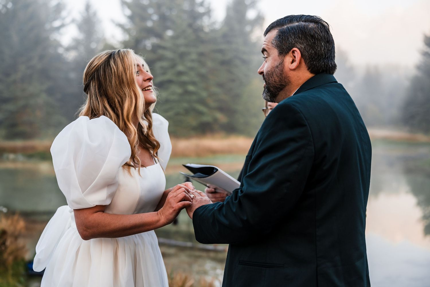 A couple shares an intimate moment by a misty lake during a romantic outdoor photo session.