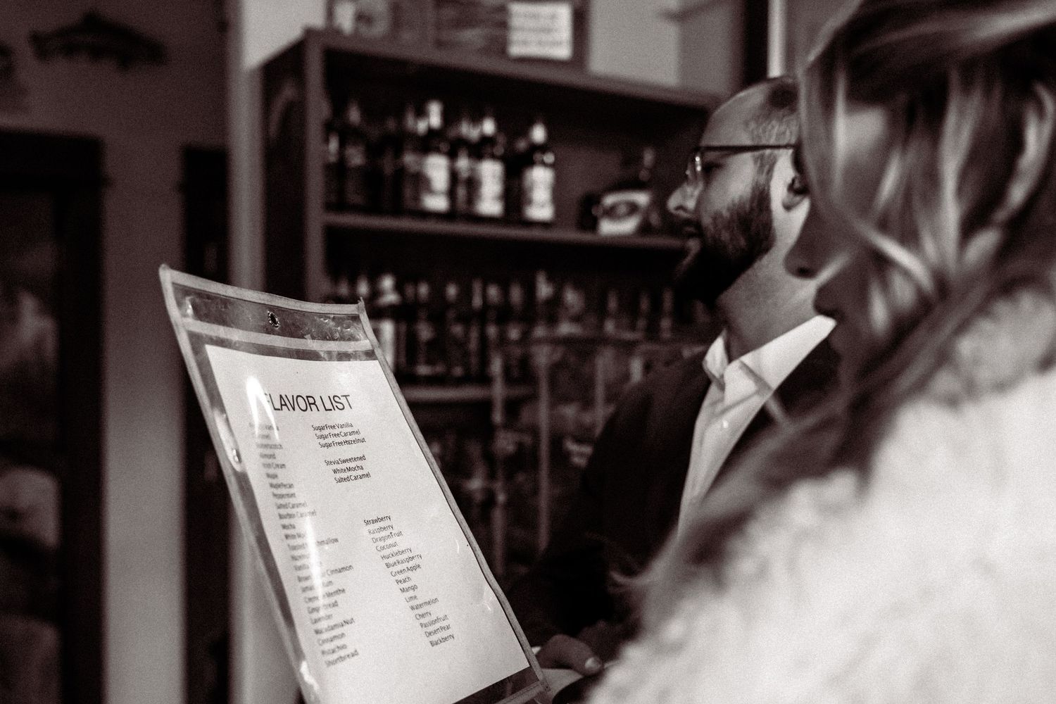 A collection of black and white photos showing bartenders mixing drinks and serving customers at a bar.