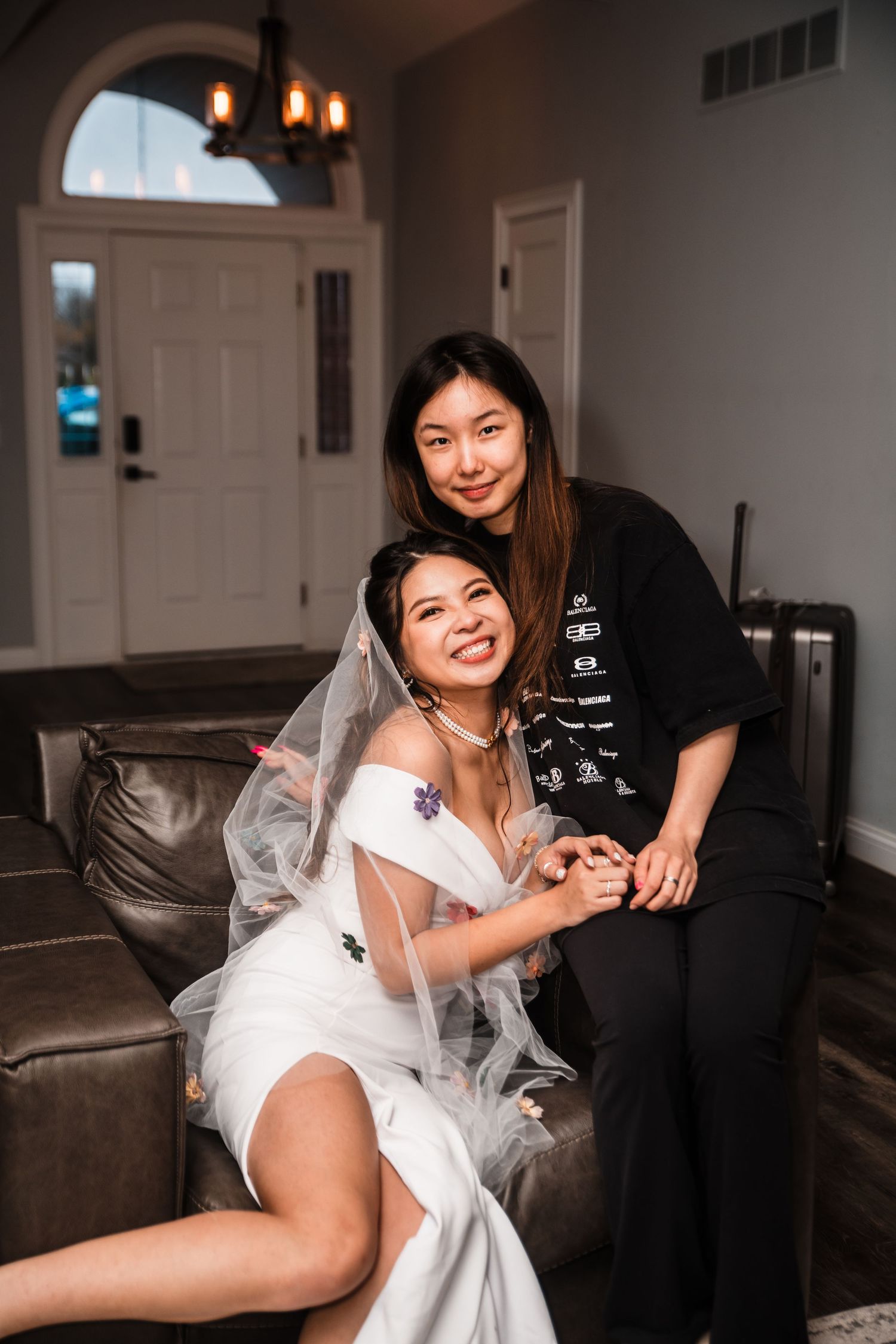 Two people share an intimate moment on a leather couch during wedding celebrations.