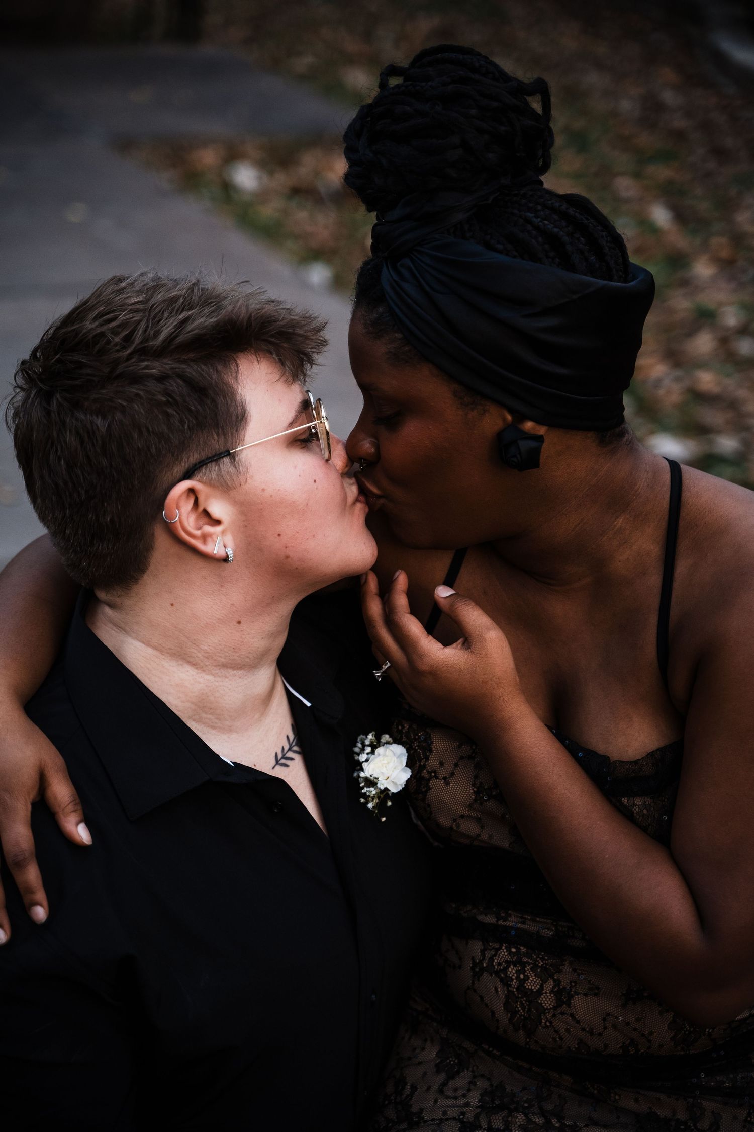 Intimate moment between couple in formal attire during outdoor wedding photoshoot.
