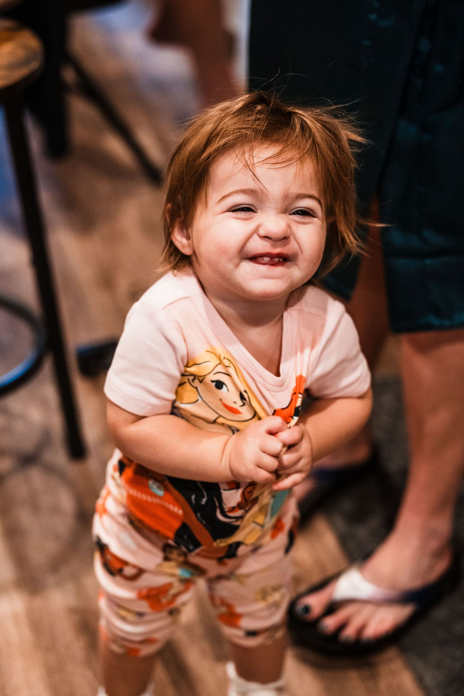 A sequence of candid photos showing a child in an orange and white outfit laughing and playing.