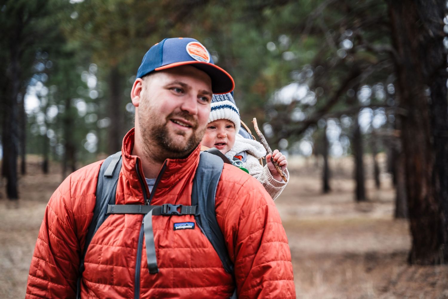 Outdoor enthusiasts enjoying a hike through a pine forest on a crisp day.