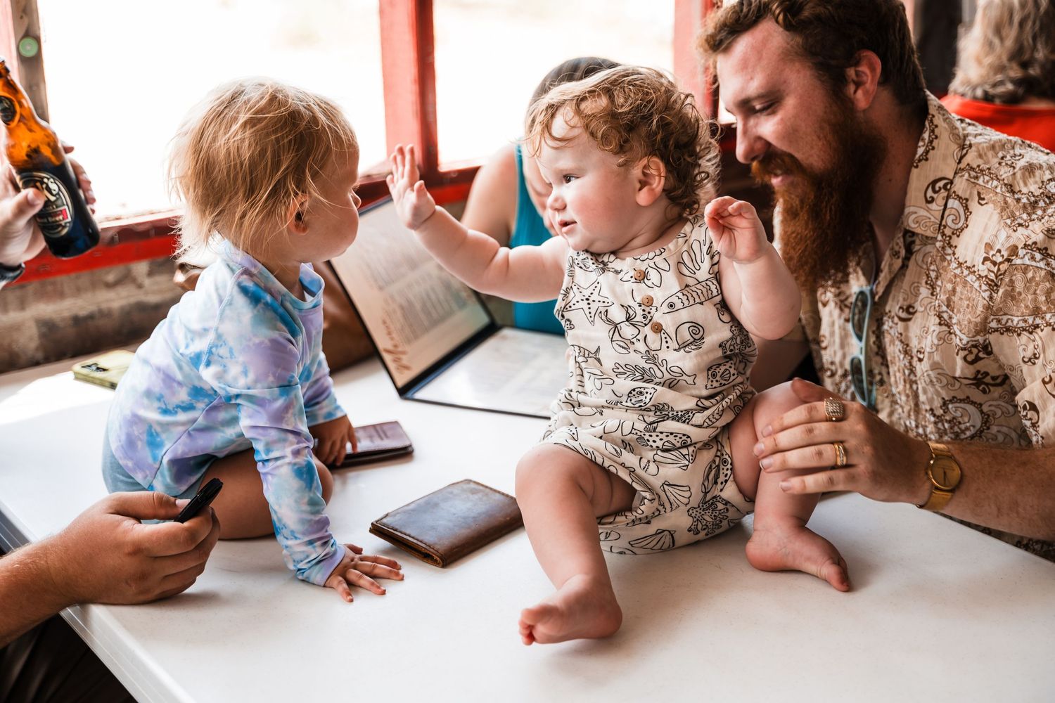 Casual family gathering around a dining table with children and adults sharing a meal together.