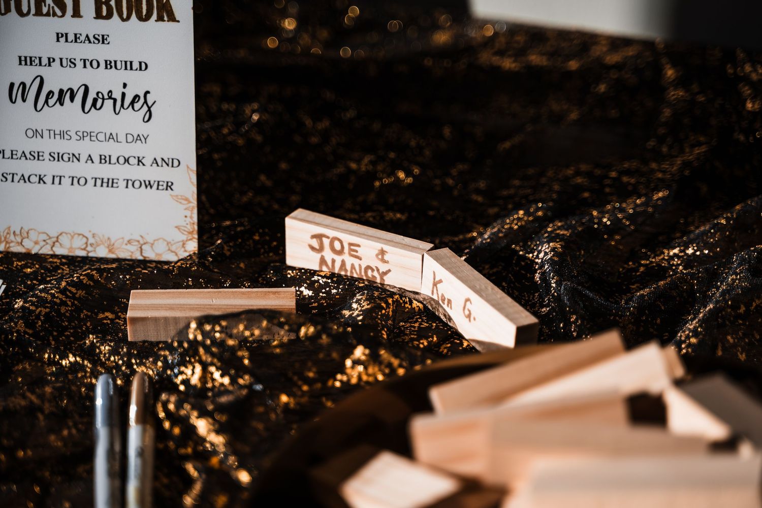 Wedding guest book and memory cards displayed on dark surface with golden lighting.