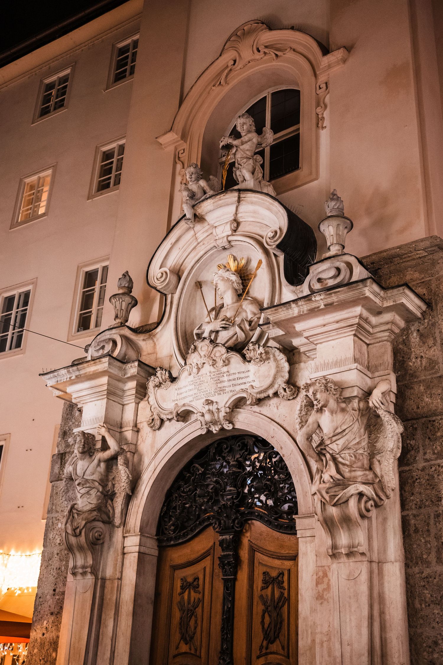 Baroque architectural details with ornate stone arches and sculptural elements on a historic building facade.