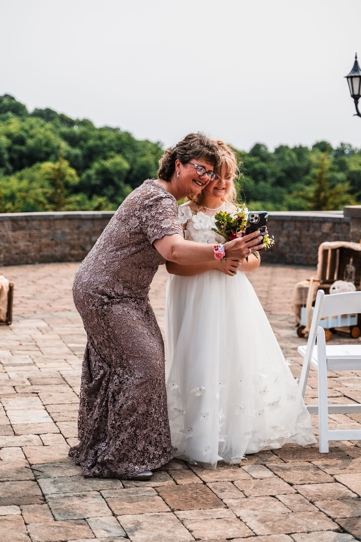An emotional moment captured between two people sharing a warm embrace during a wedding celebration on a stone terrace.