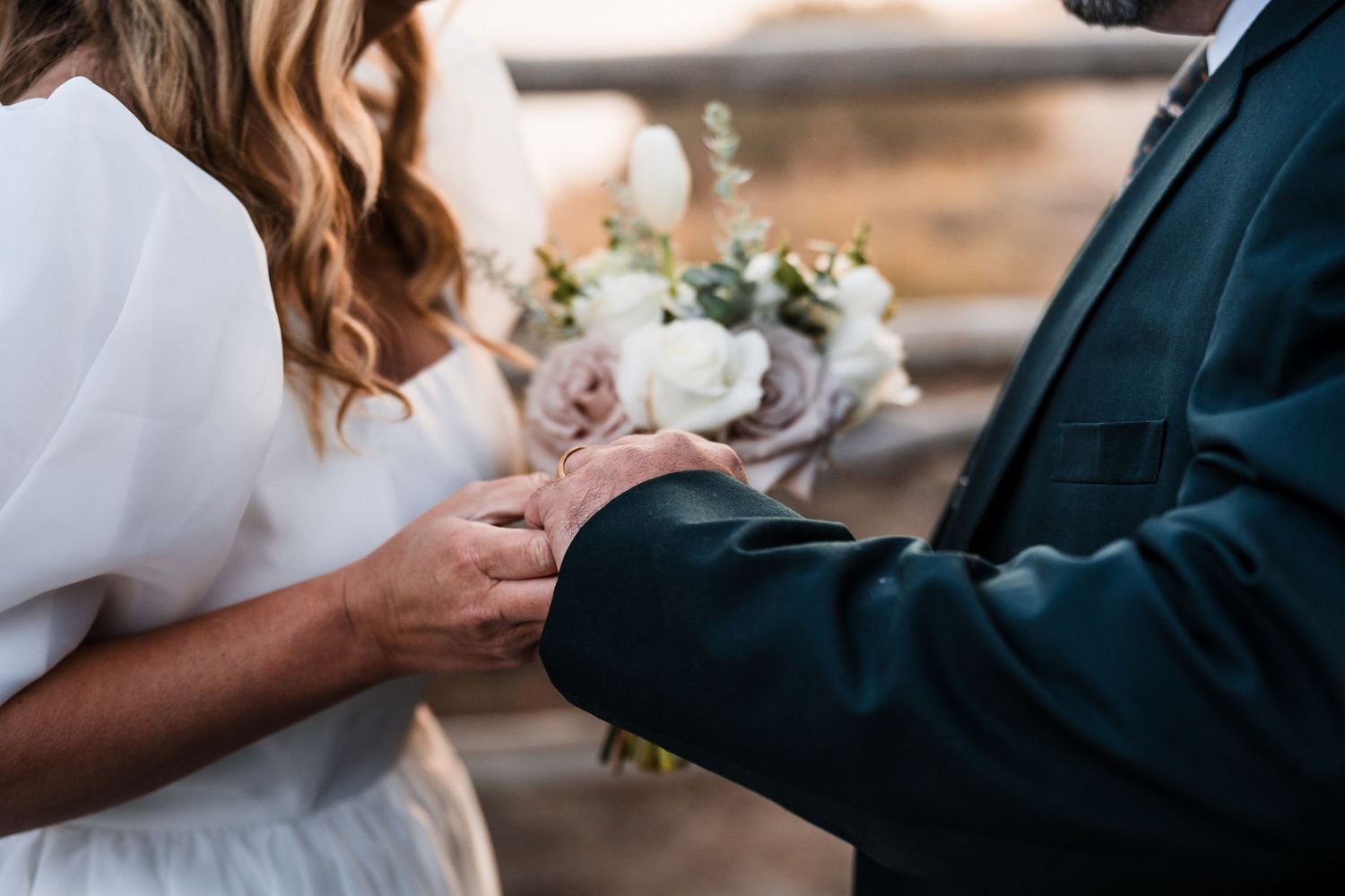 Close-up details of a bride and groom embracing during their wedding ceremony.