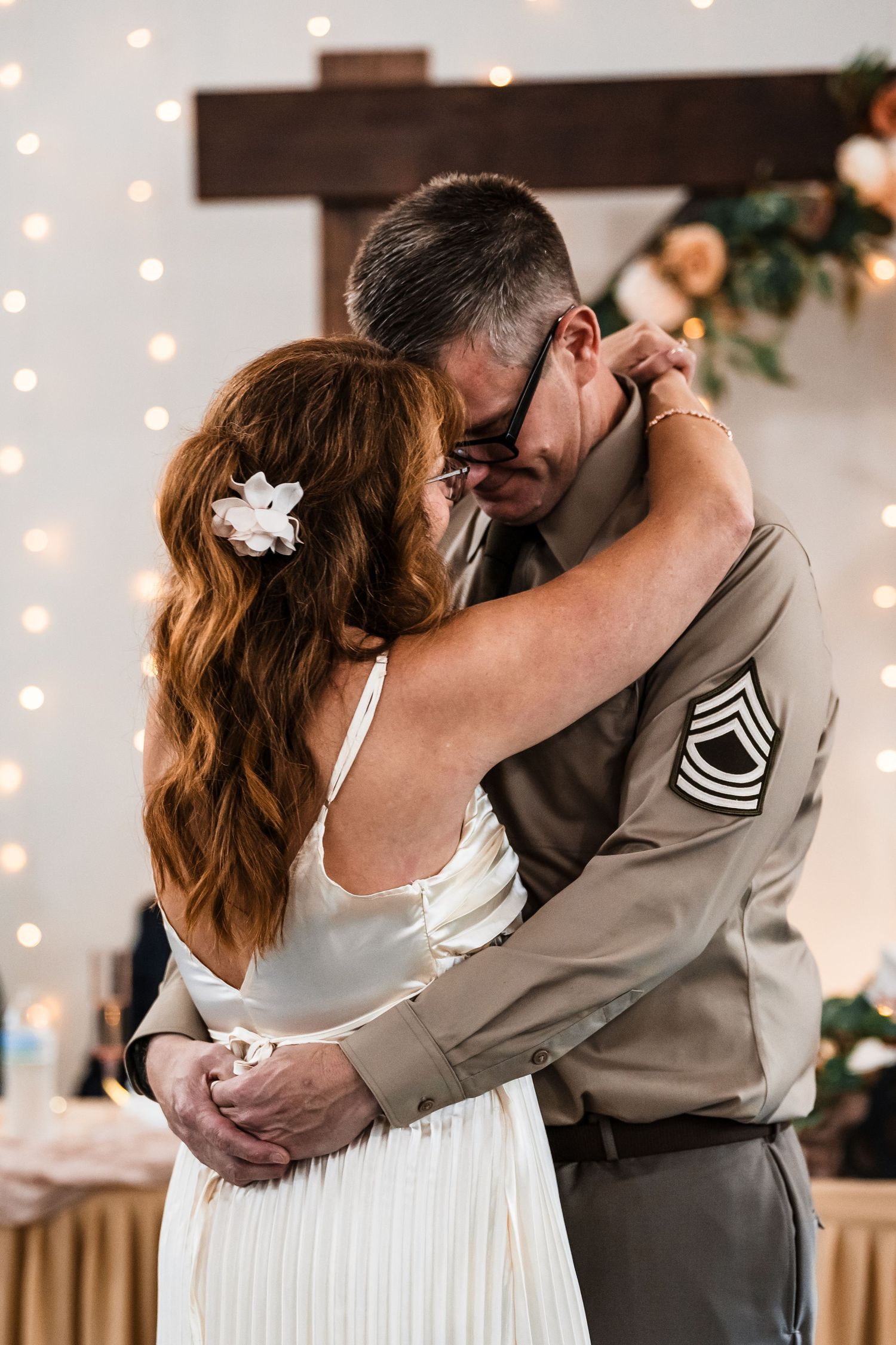 A romantic wedding moment captured with twinkle lights glowing in the background.