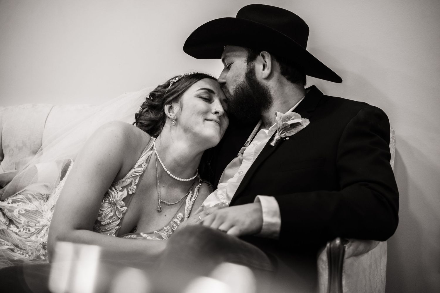 A tender black and white portrait captures an intimate wedding moment.