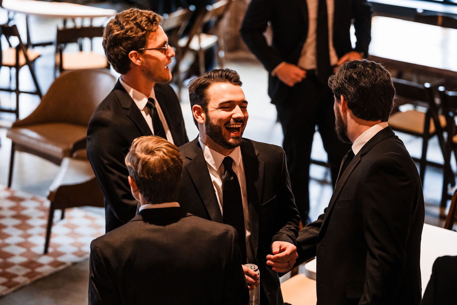 A group of formally dressed people engaged in animated conversation at an event.