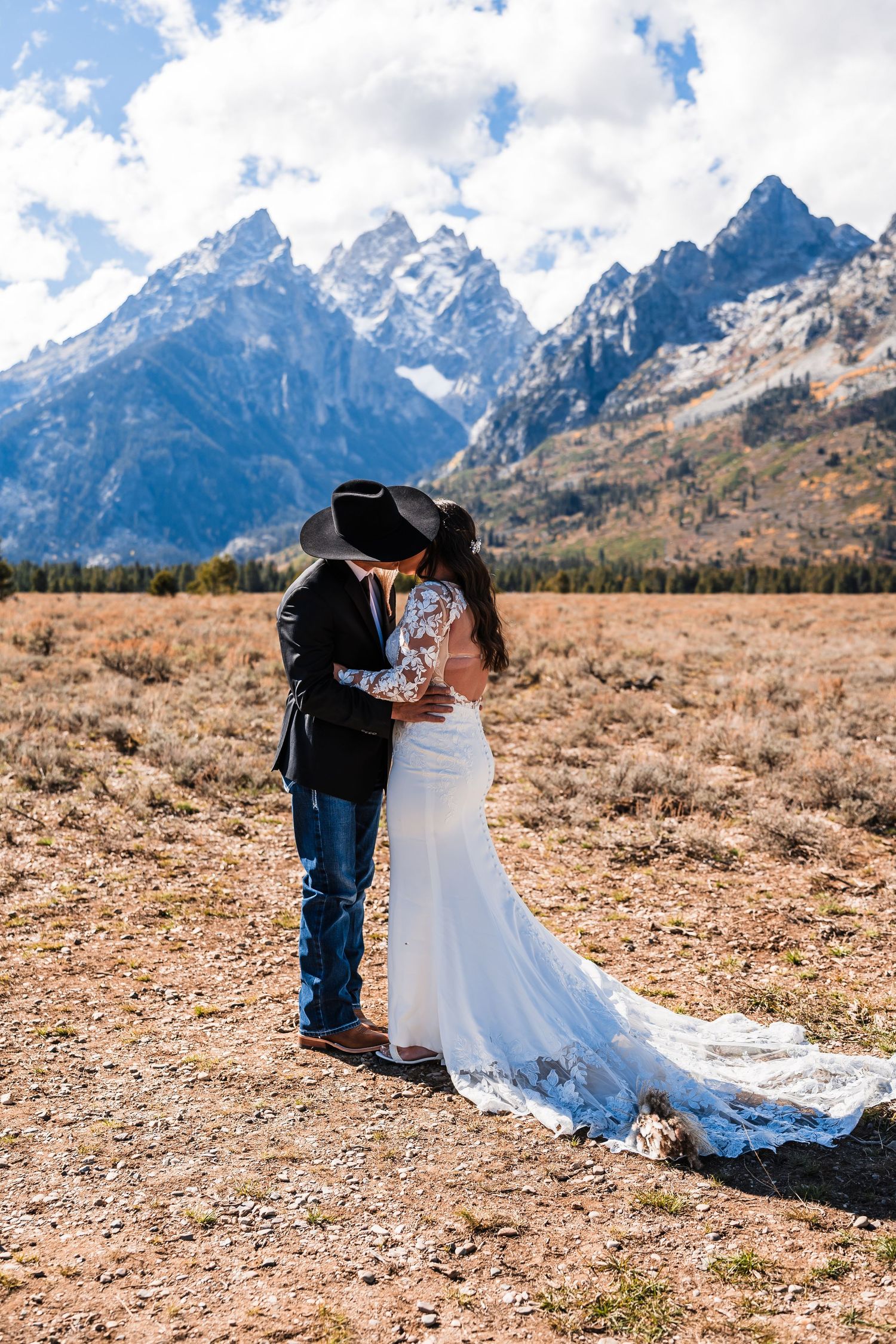 An intimate outdoor wedding moment captured in a rugged mountain landscape with golden grass.