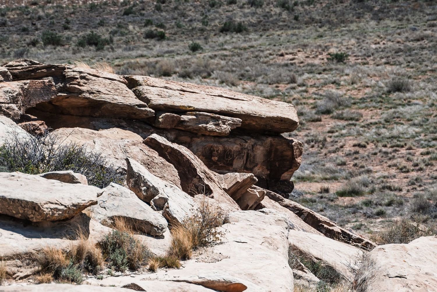 Natural rock formation with layered sandstone outcroppings in desert terrain.