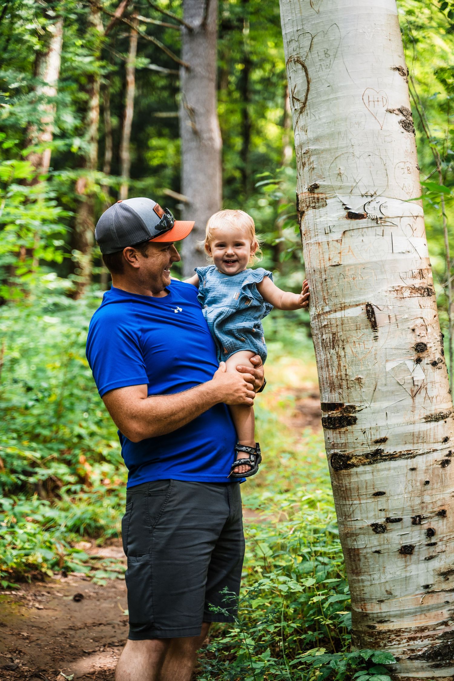 Hiking trail adventure with a large white birch tree trunk in a lush forest setting.